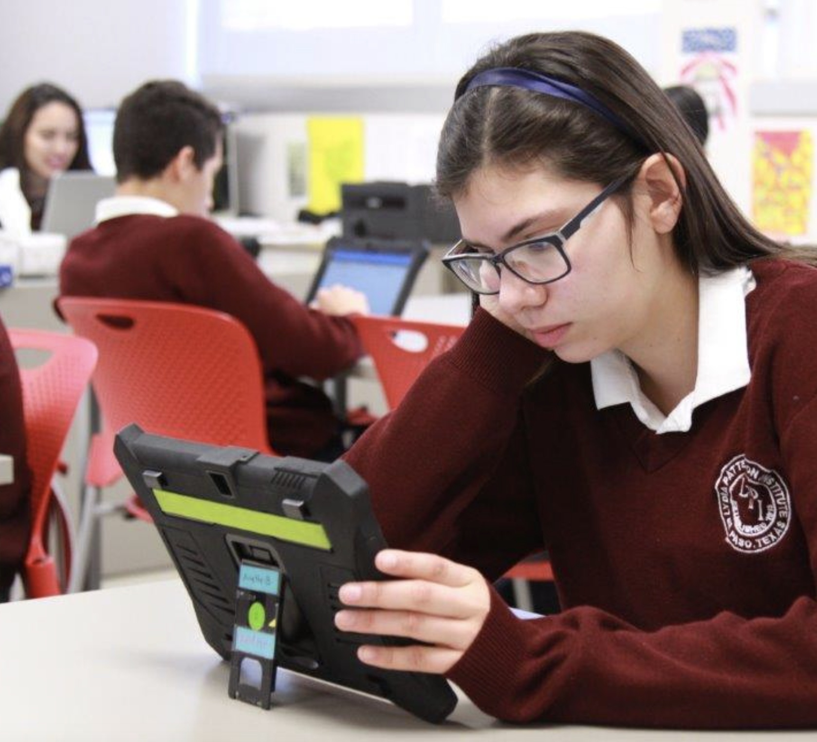 A girl holding an iPad and paying attention to something in it.