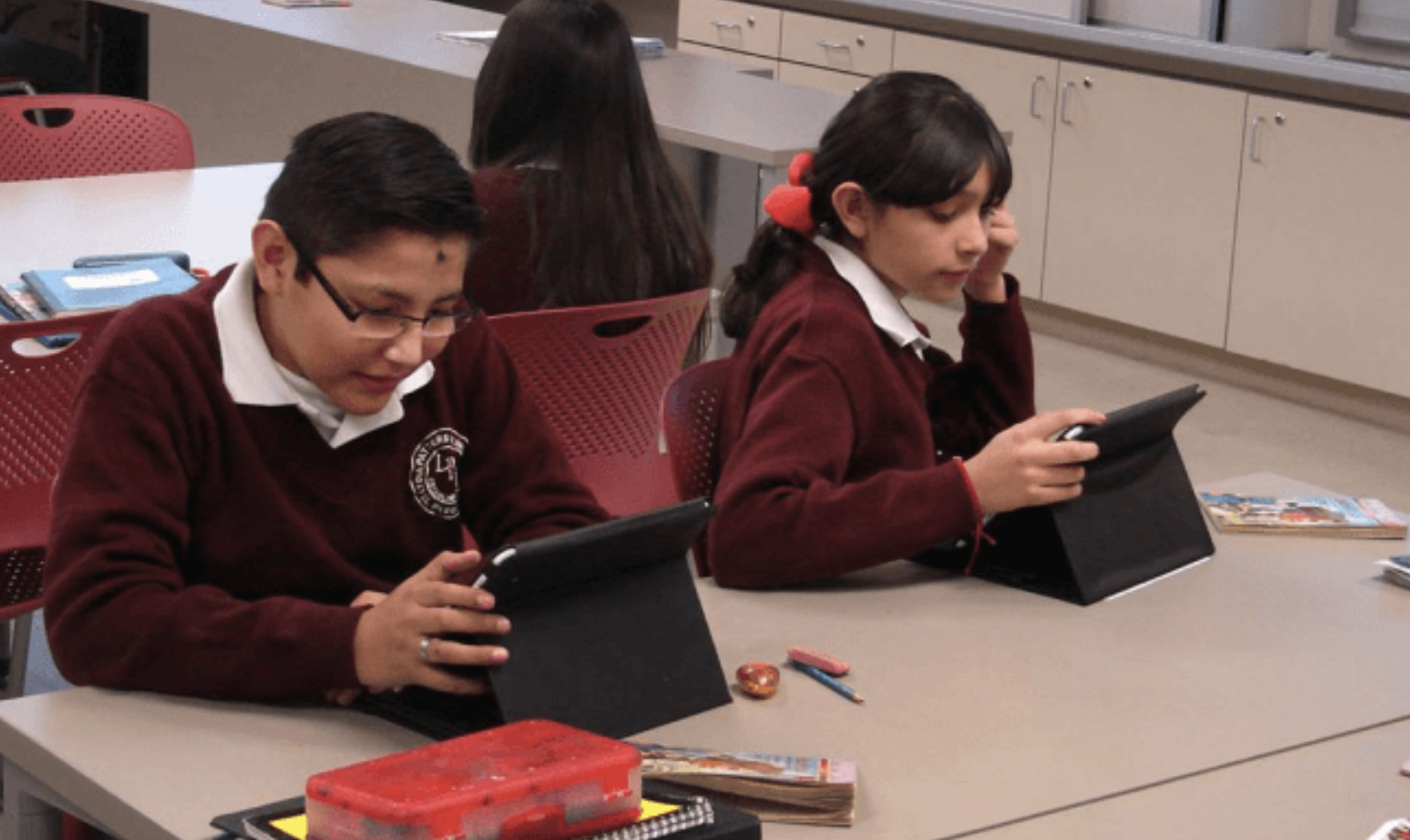 Two students using their iPads in the classroom