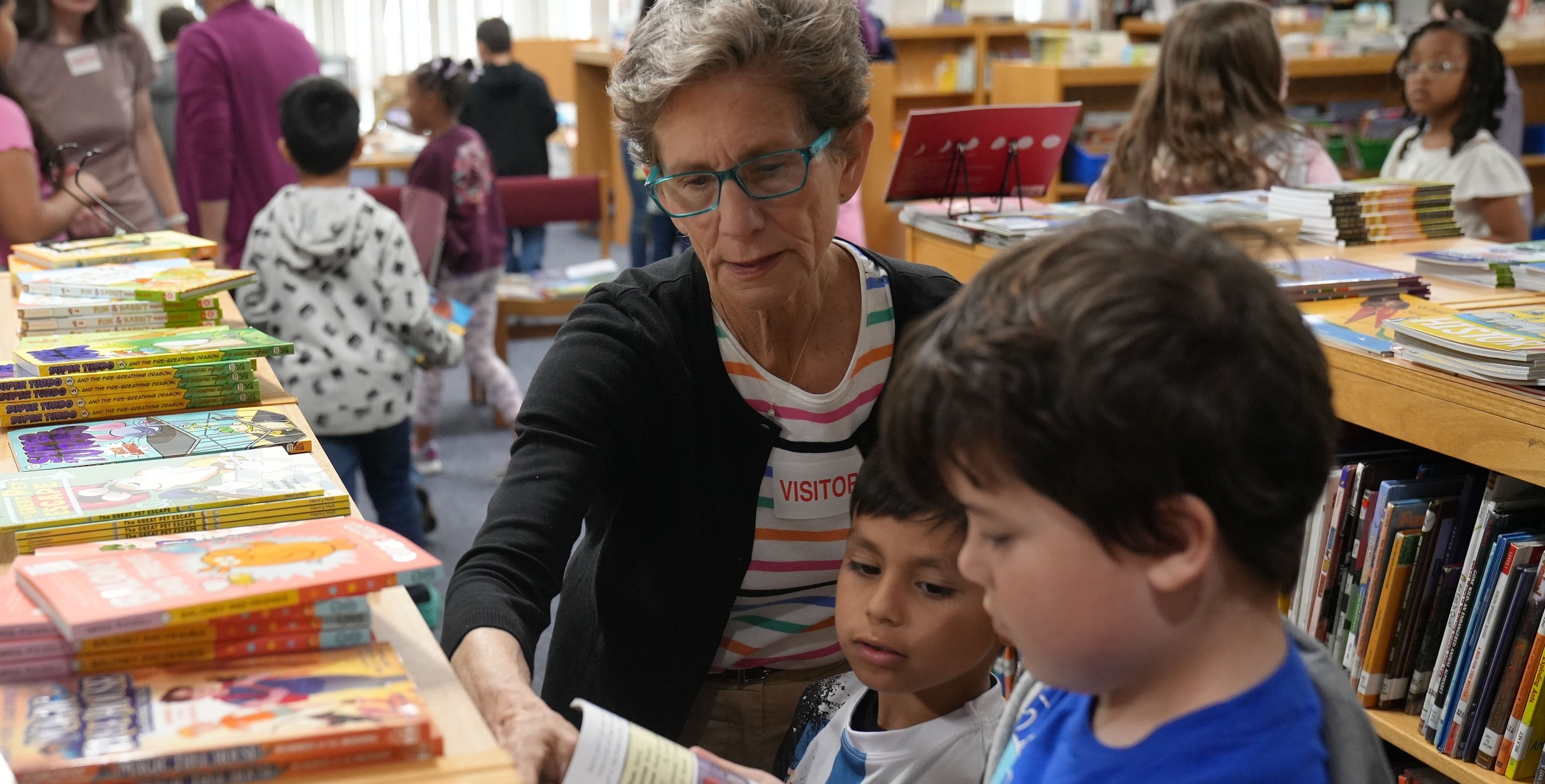 Community member reviewing book with students