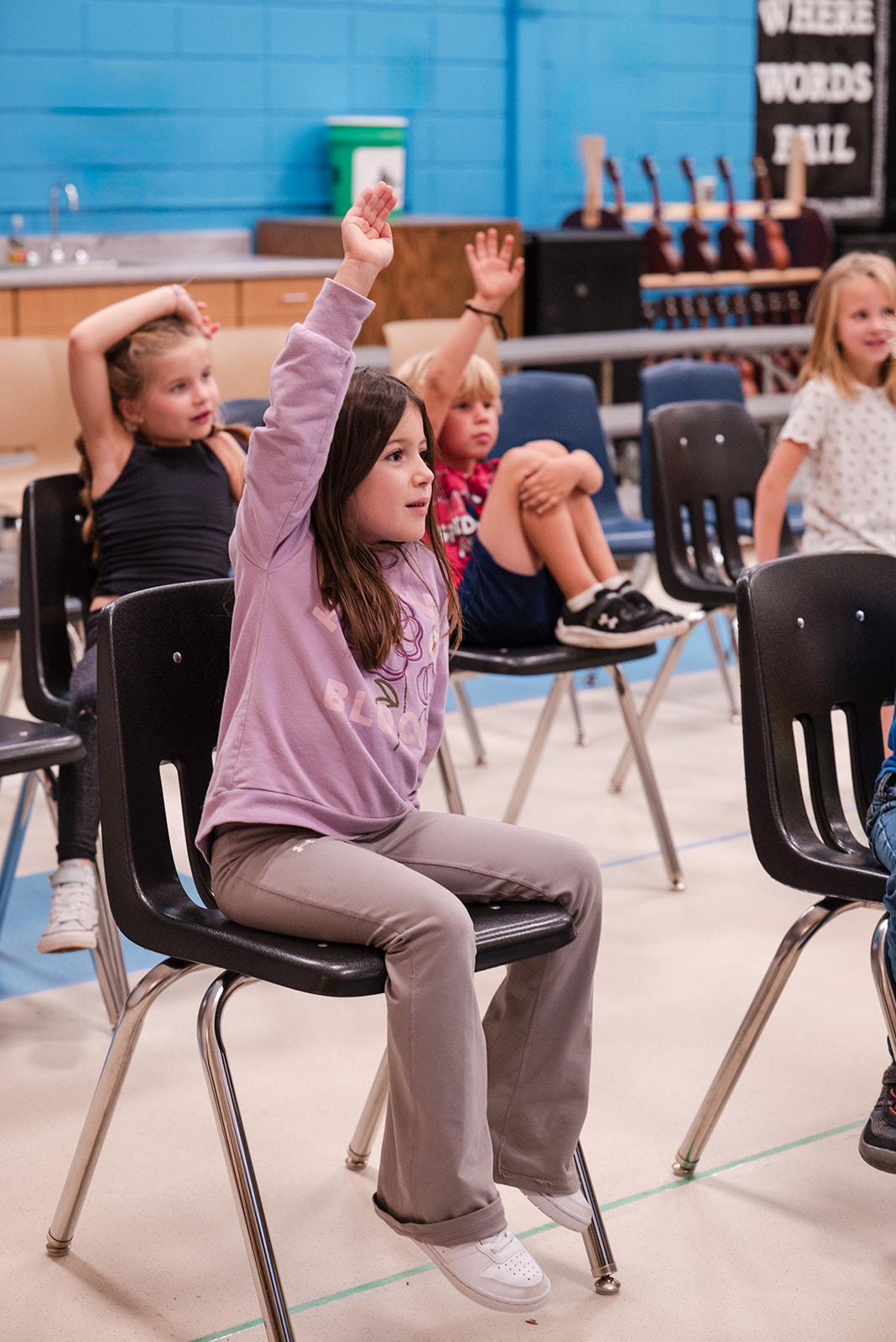 kindergarten student raising her hand in class