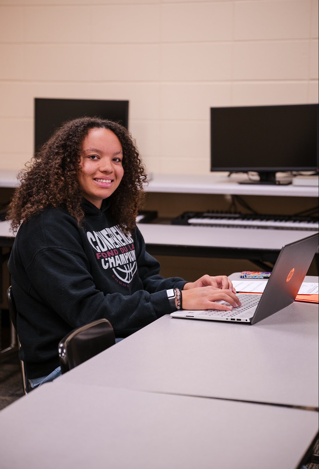 student smiling and working on laptop