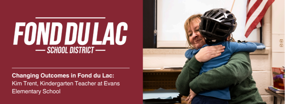 Fond du Lac School District banner with a maroon background and text: 'Changing Outcomes in Fond du Lac: Kim Trent, Kindergarten Teacher at Evans Elementary School giving a child a hug in the classroom