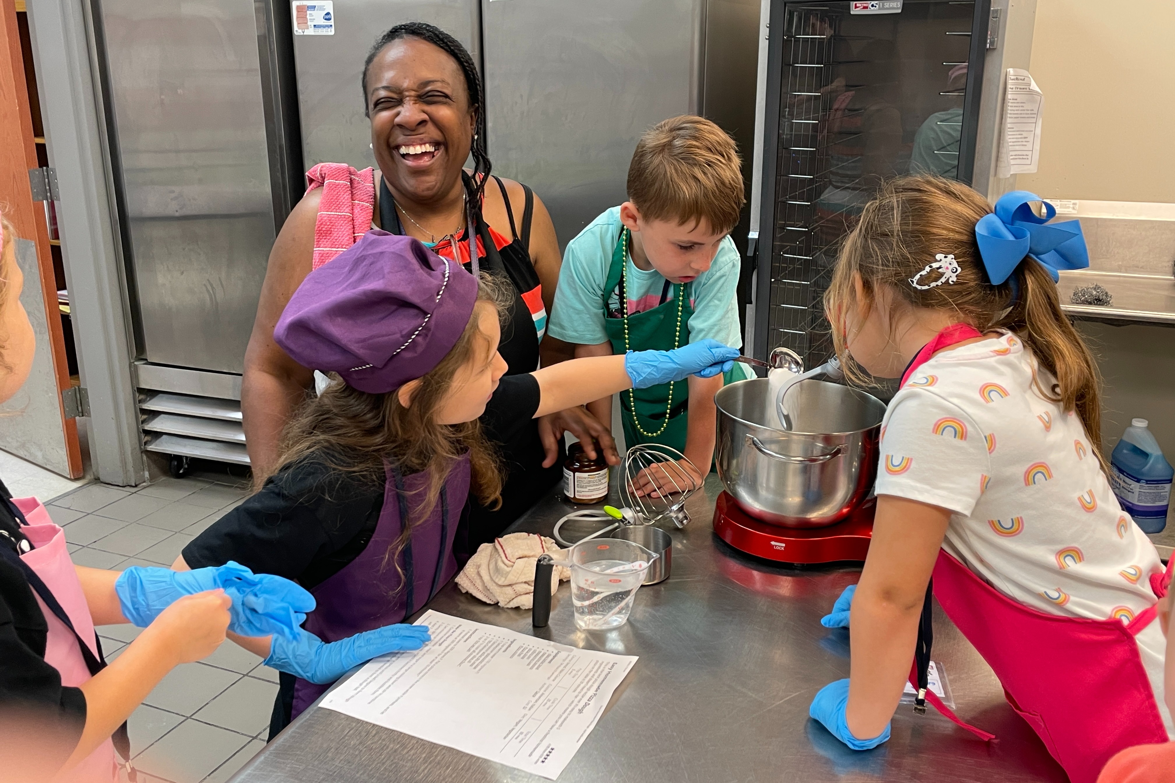 Culinary camp students work together to make pizza dough