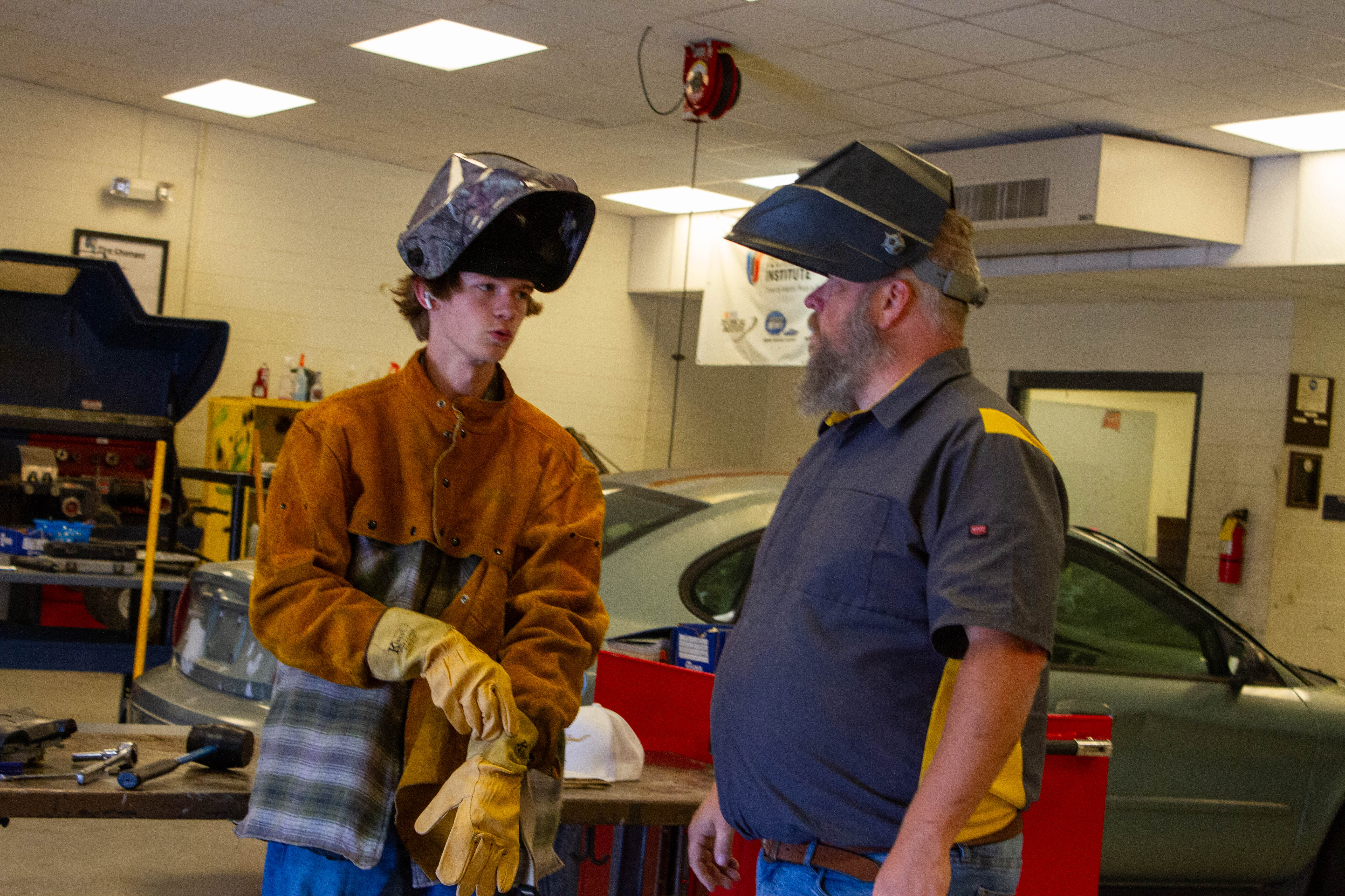 Automotive Instructor at LCHS, Mr. Eller, instructs a student prior to a welding exercise.