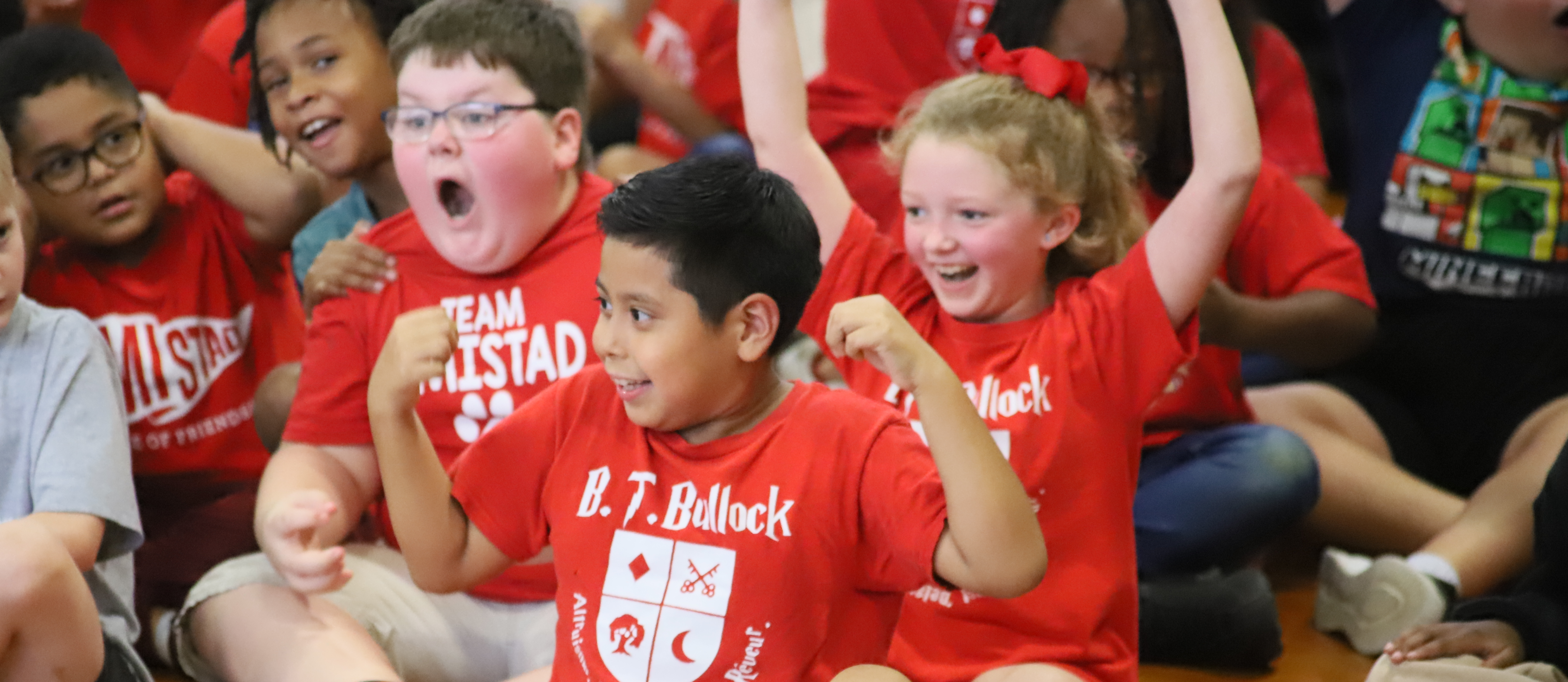 BT Bullock House Assembly and students cheering in red shirts