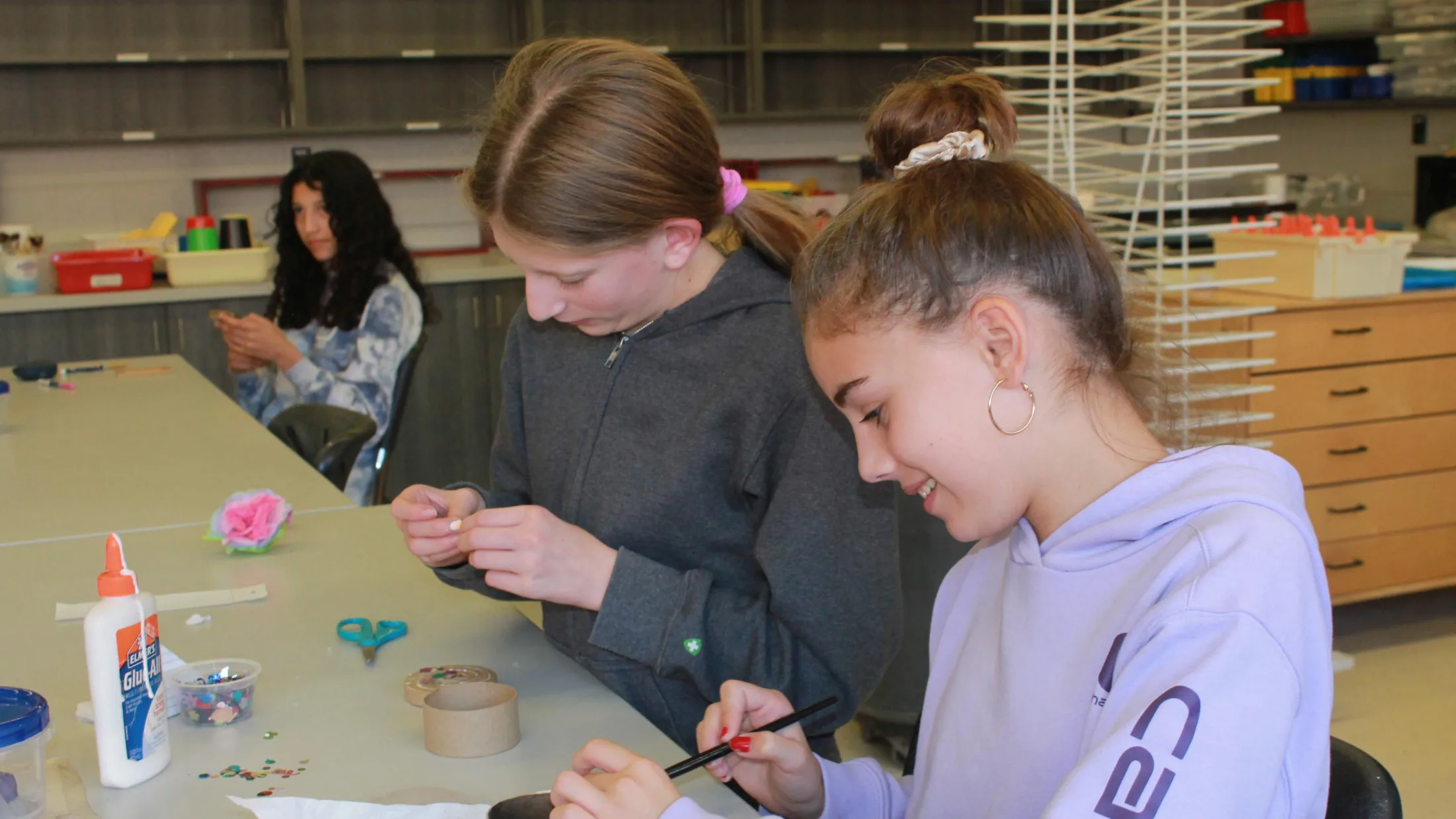 two female students working on a craft in art class.