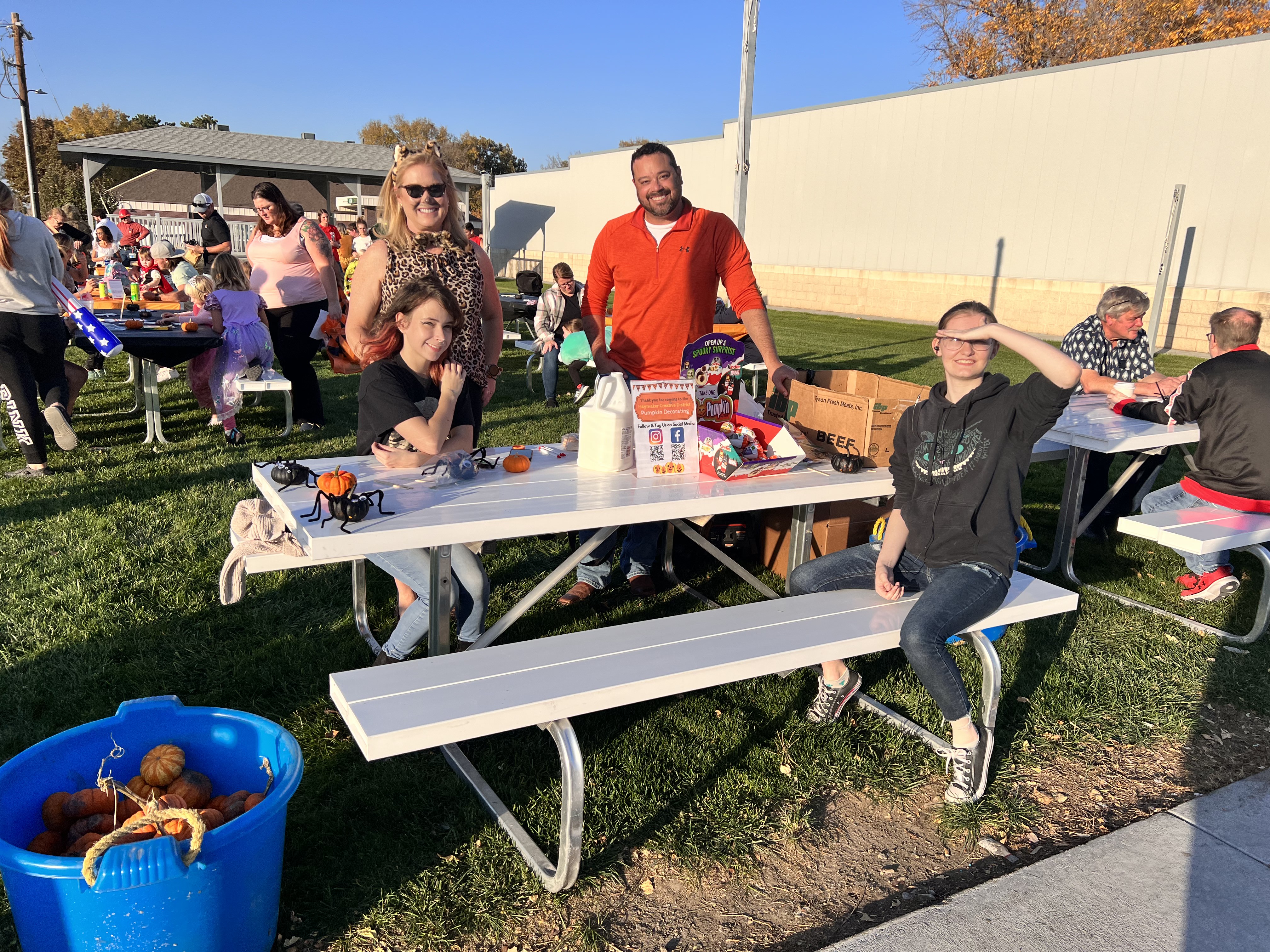 Haymaker Creative District committee members and honors art students handing out mini pumpkins to be decorated