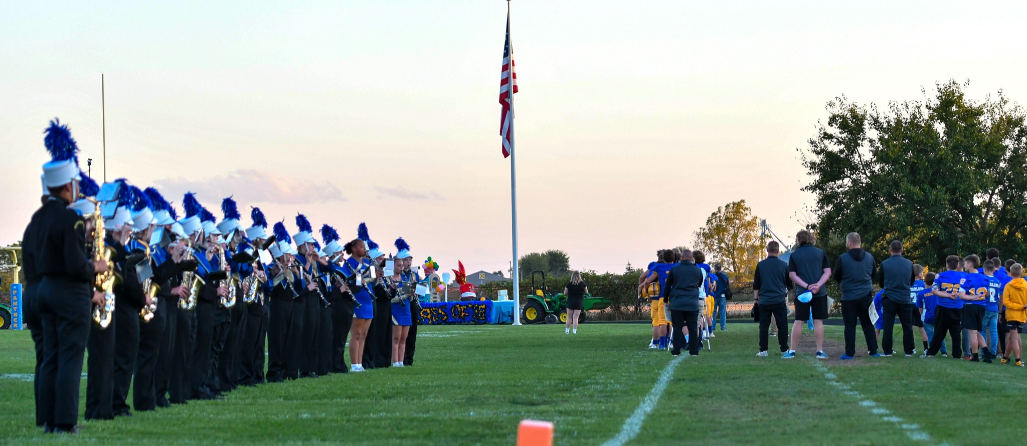 The Birch Run High School band and others face the flag in anticipation of the National Anthem.