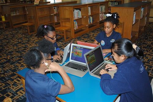 students sitting using their laptop