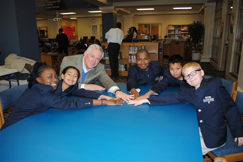 Students sitting on a table with a school staff