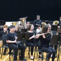 band members play instrument sitting behind music stands