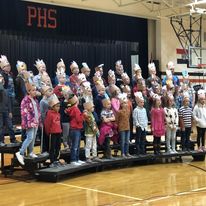 students stand on risers to perform music