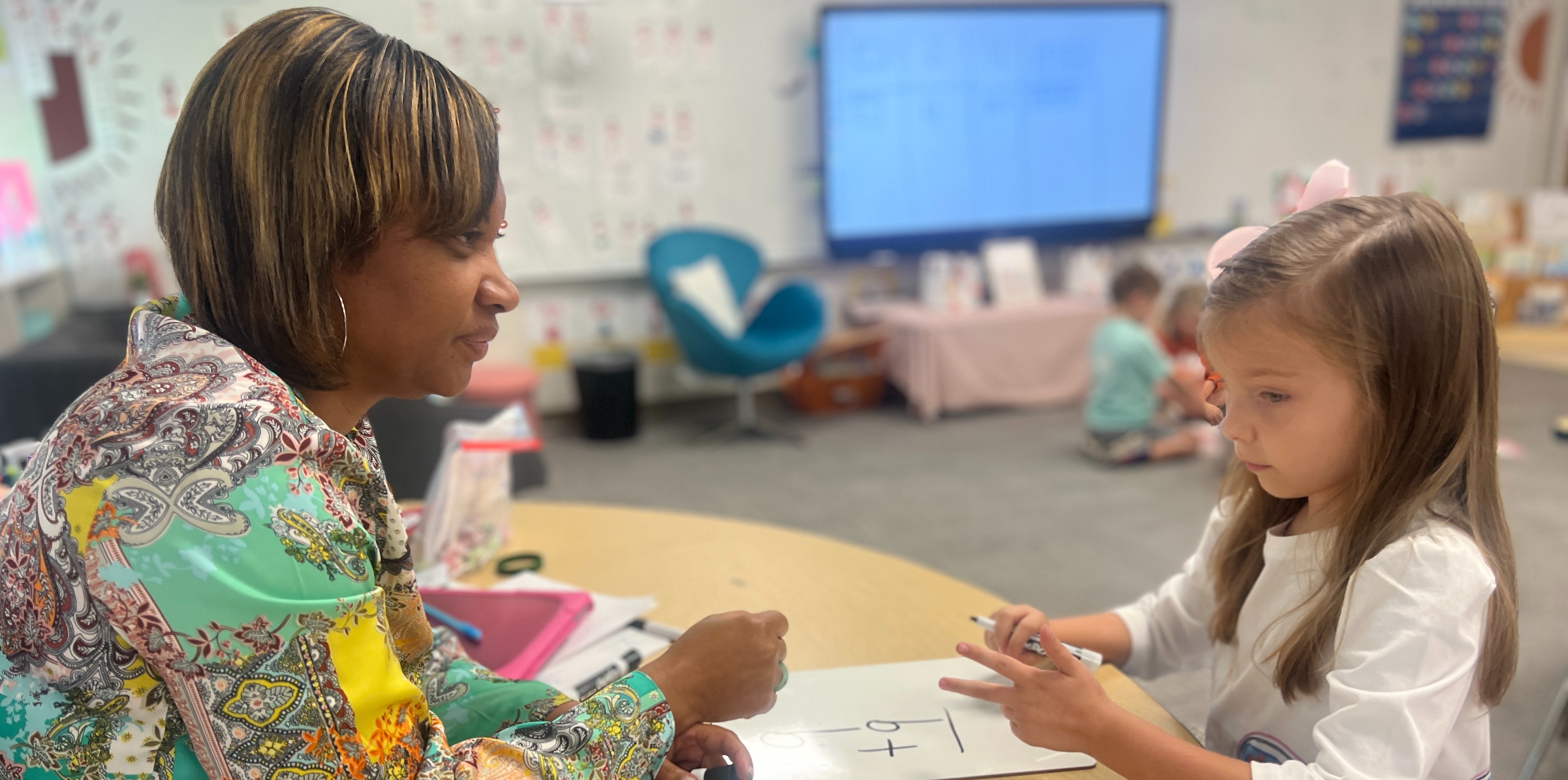 teacher with a student doing a math problem