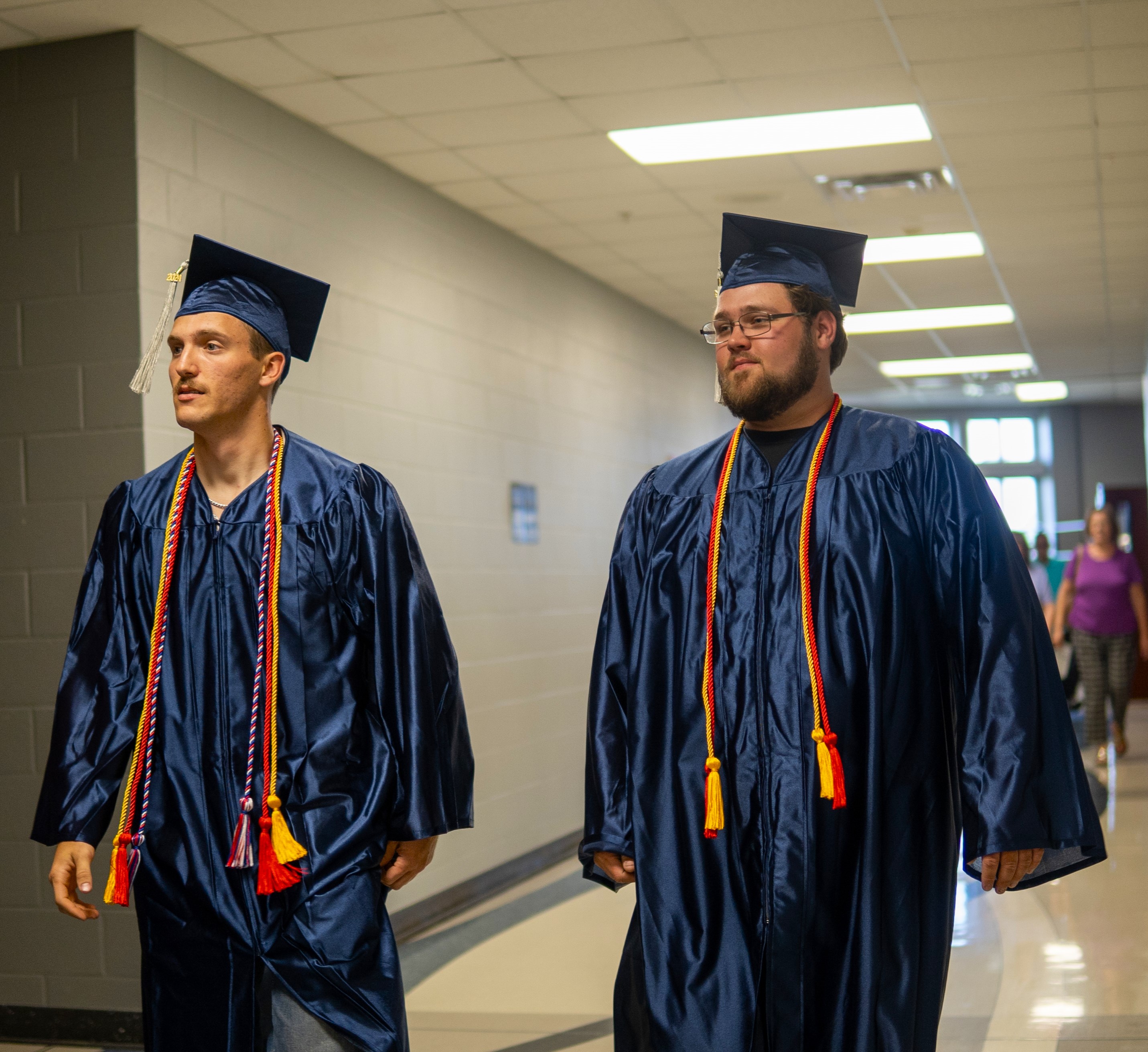 two grads walk down the hallway