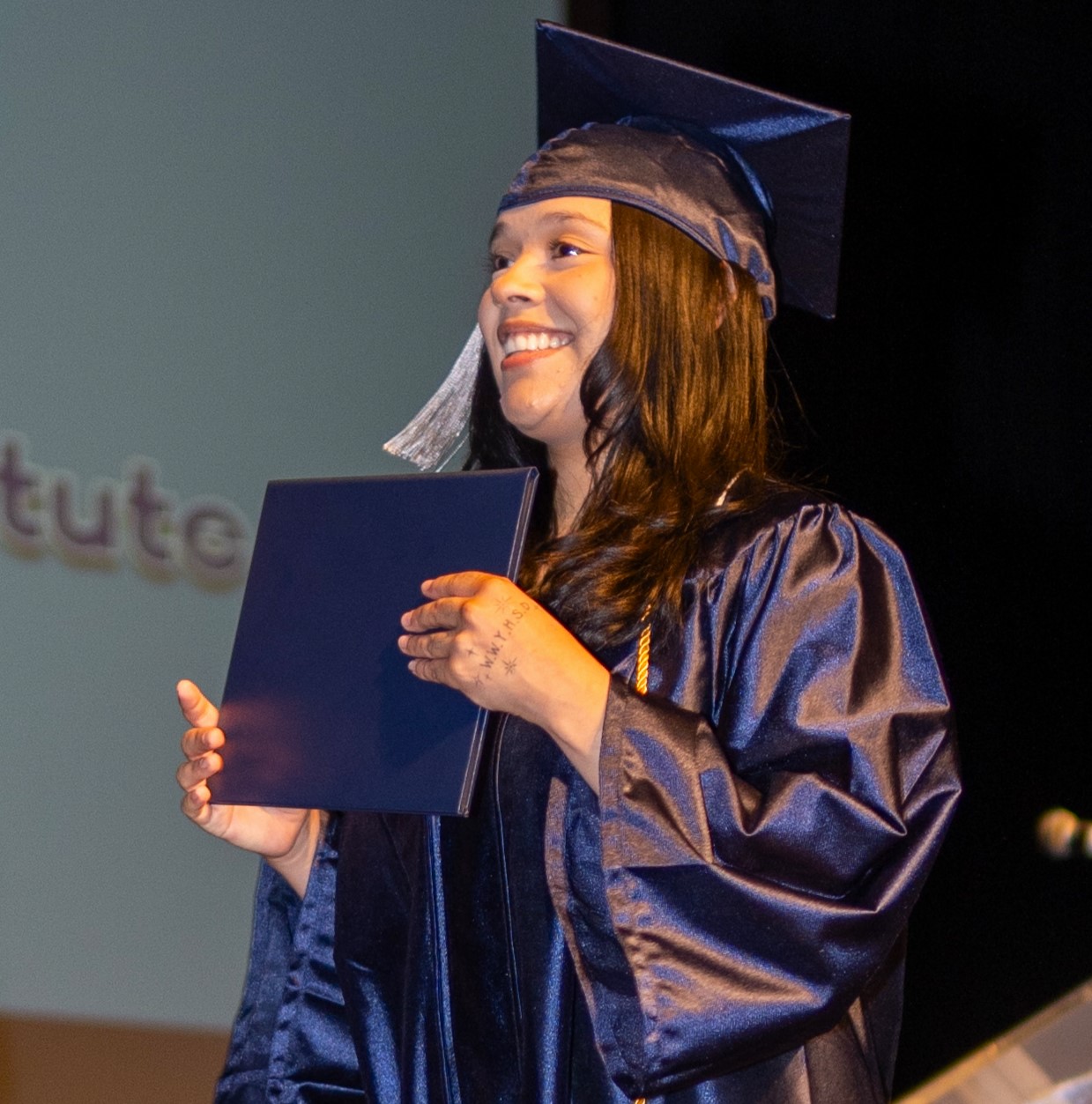 close of student on stage with her diploma