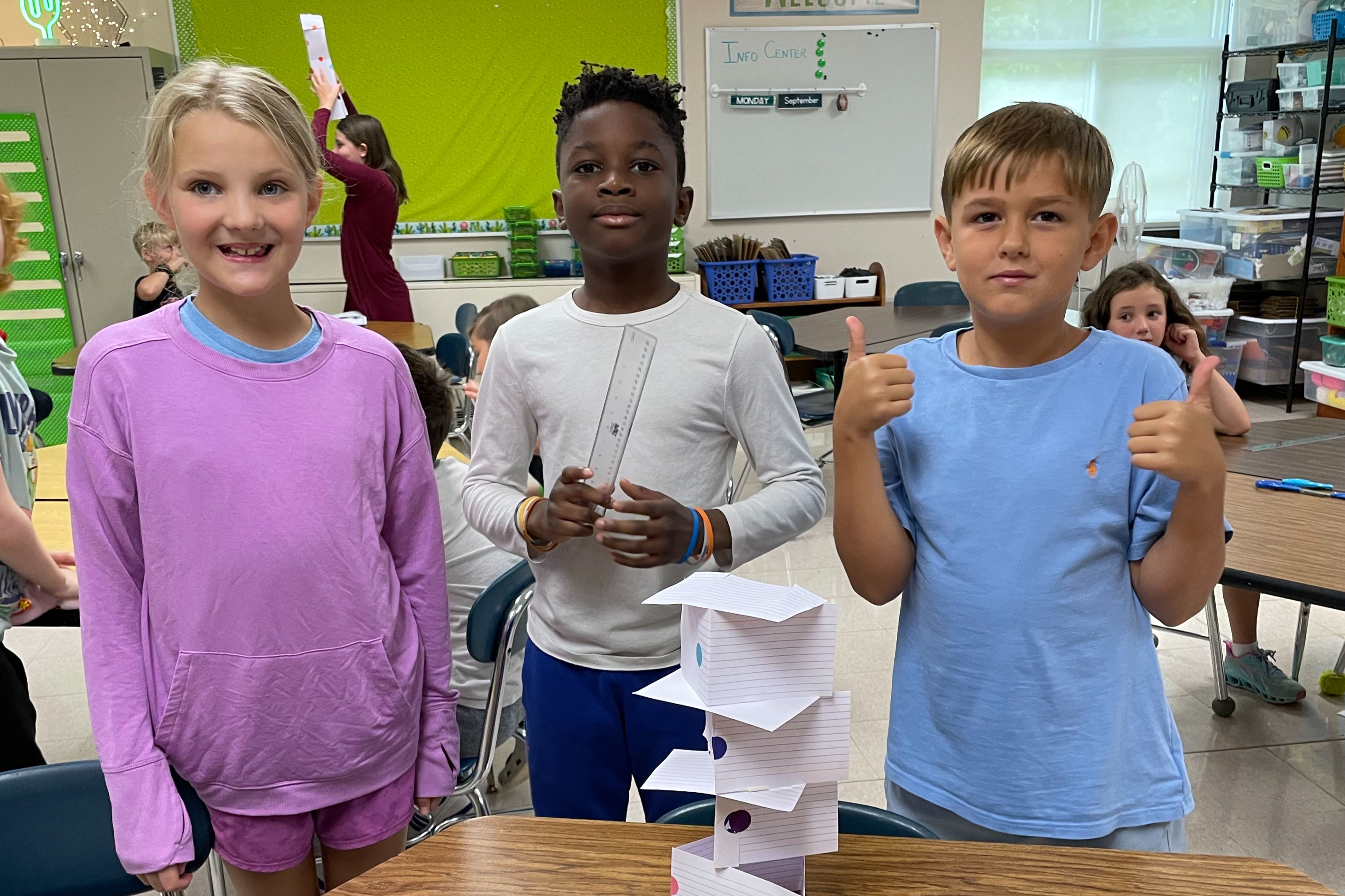 three kids with stacked paper project