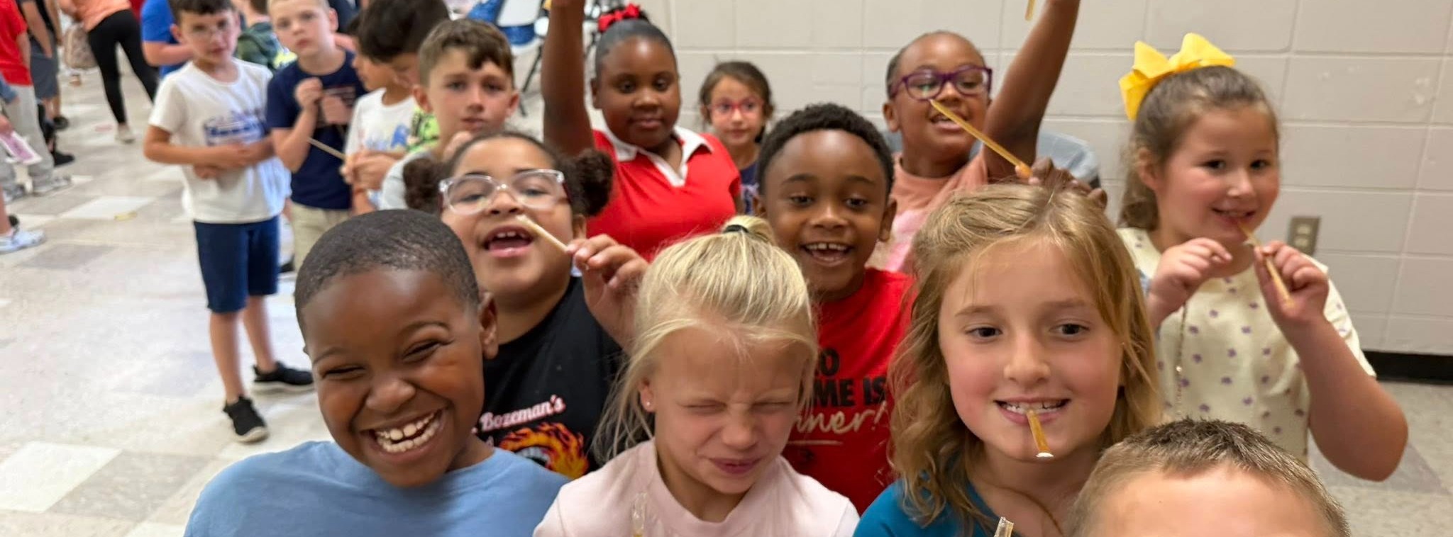 Students raising their hands and smiling