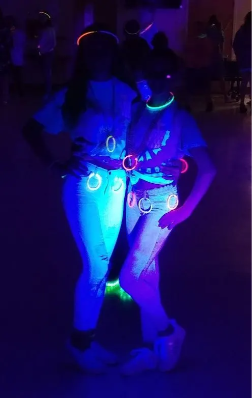 Two girls "Show their Glow" at the Spring Builder's Club Black Light Dance.