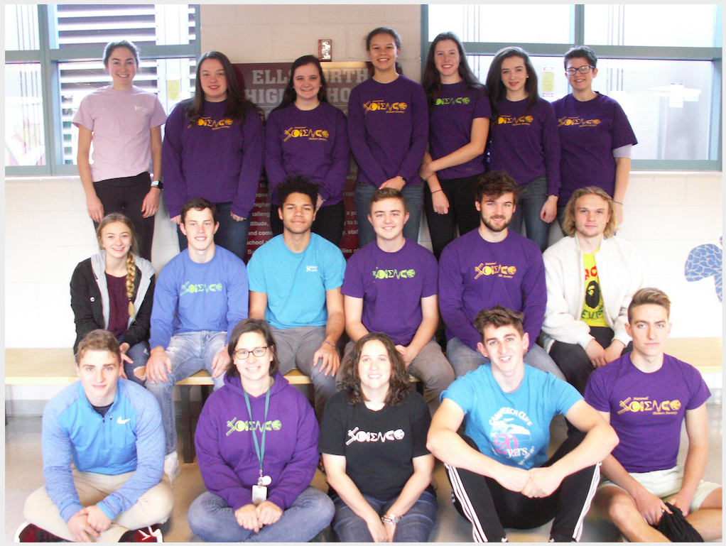 A photo of a group of students members of the club with a purple t-shirt.