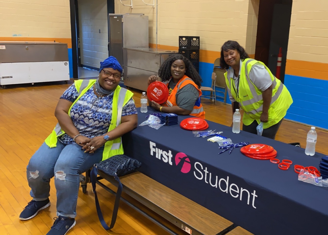 First Student bus drivers smiling at table