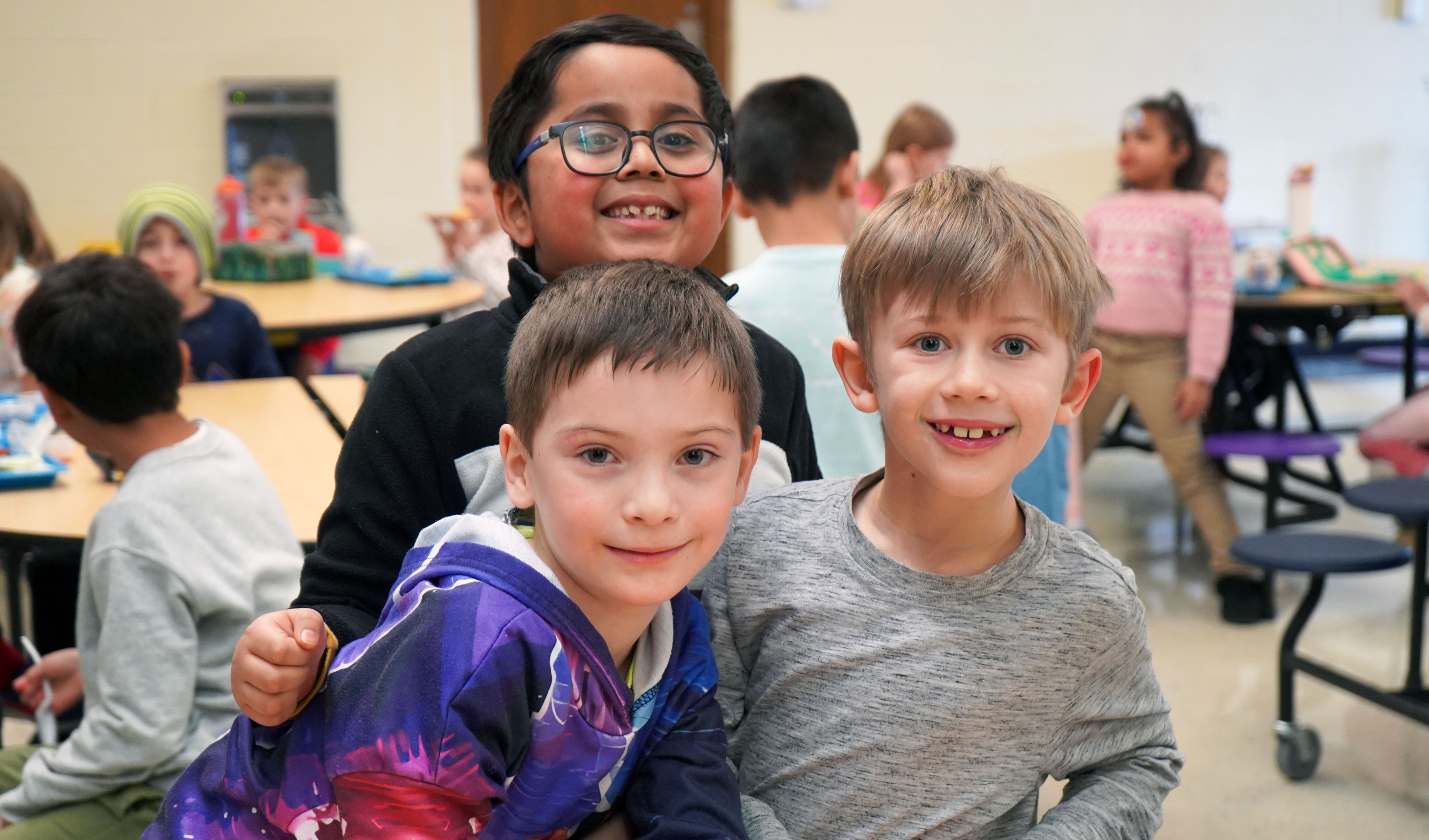 Three students in the cafeteria. 