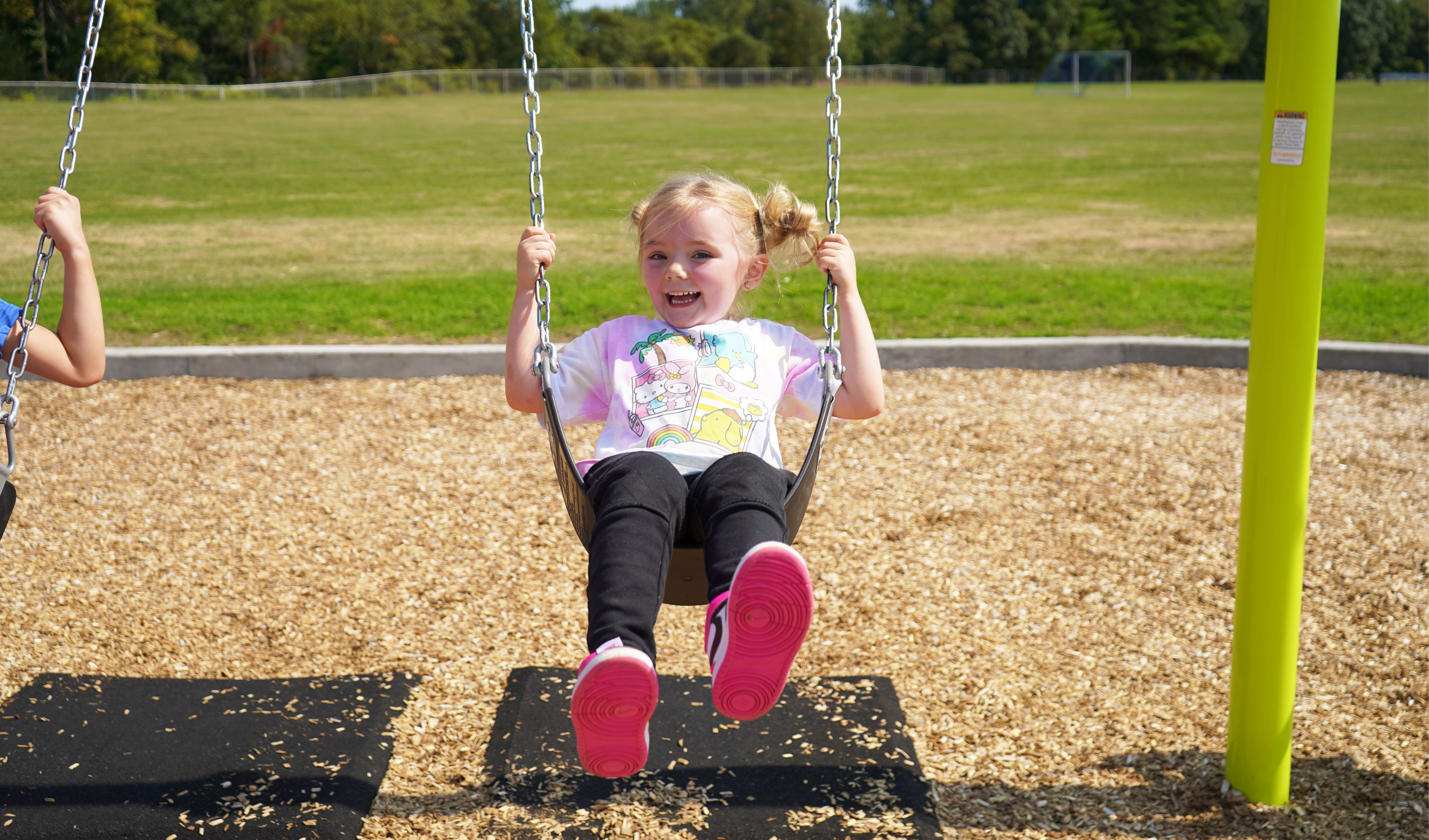 Student swings on school playground.