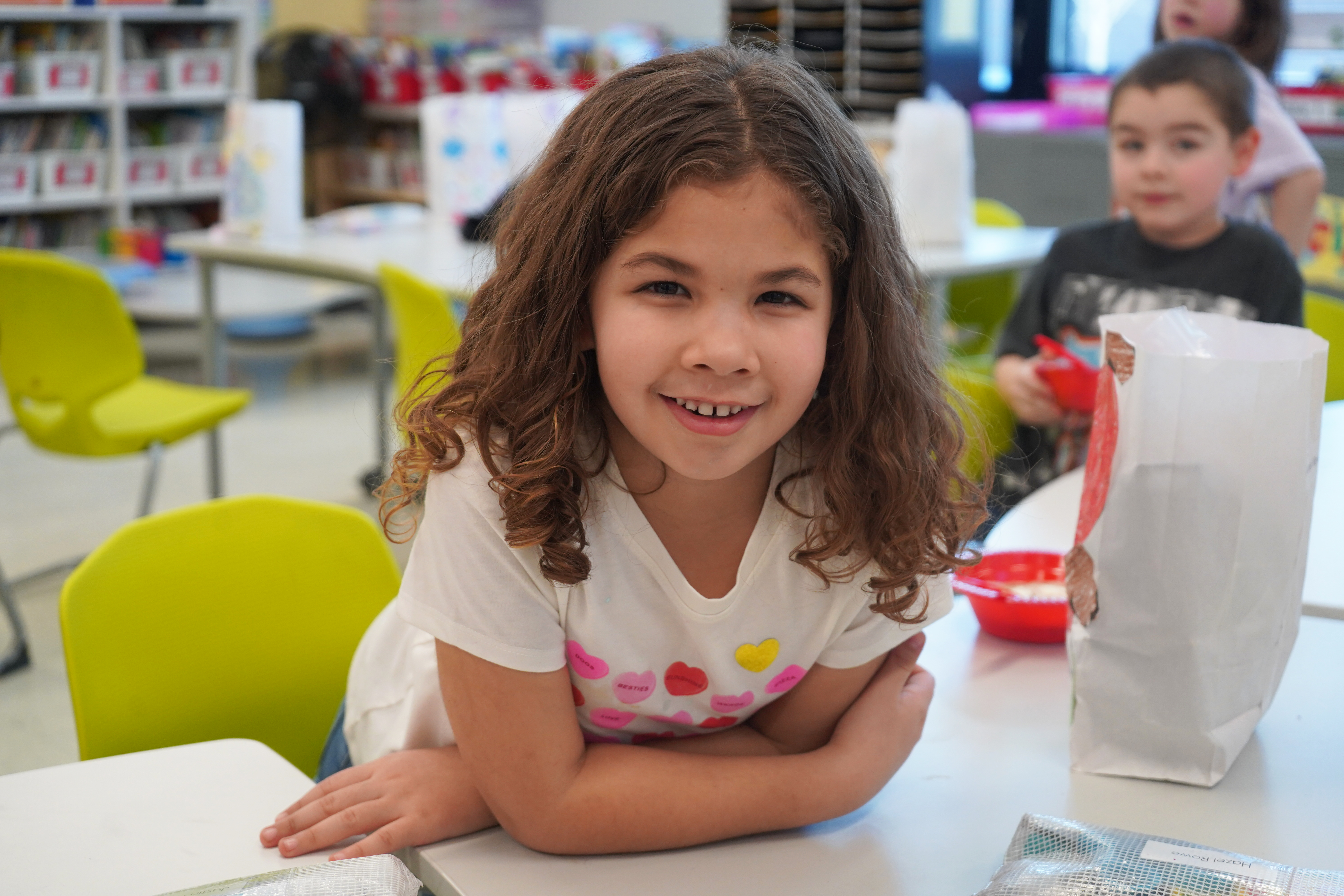 Student sits at desk during Valentine's Day party.