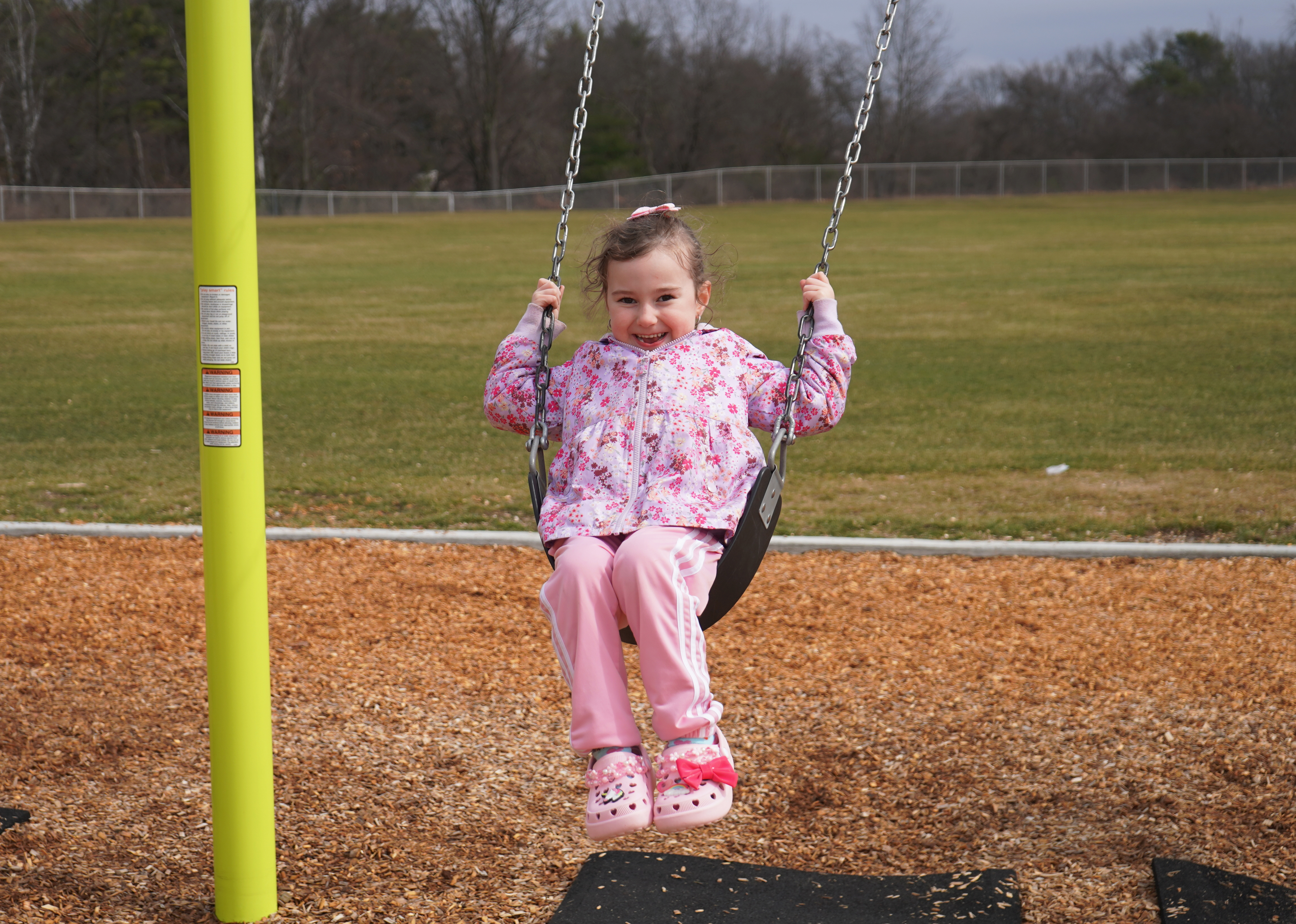 Student swings on school playground swing.