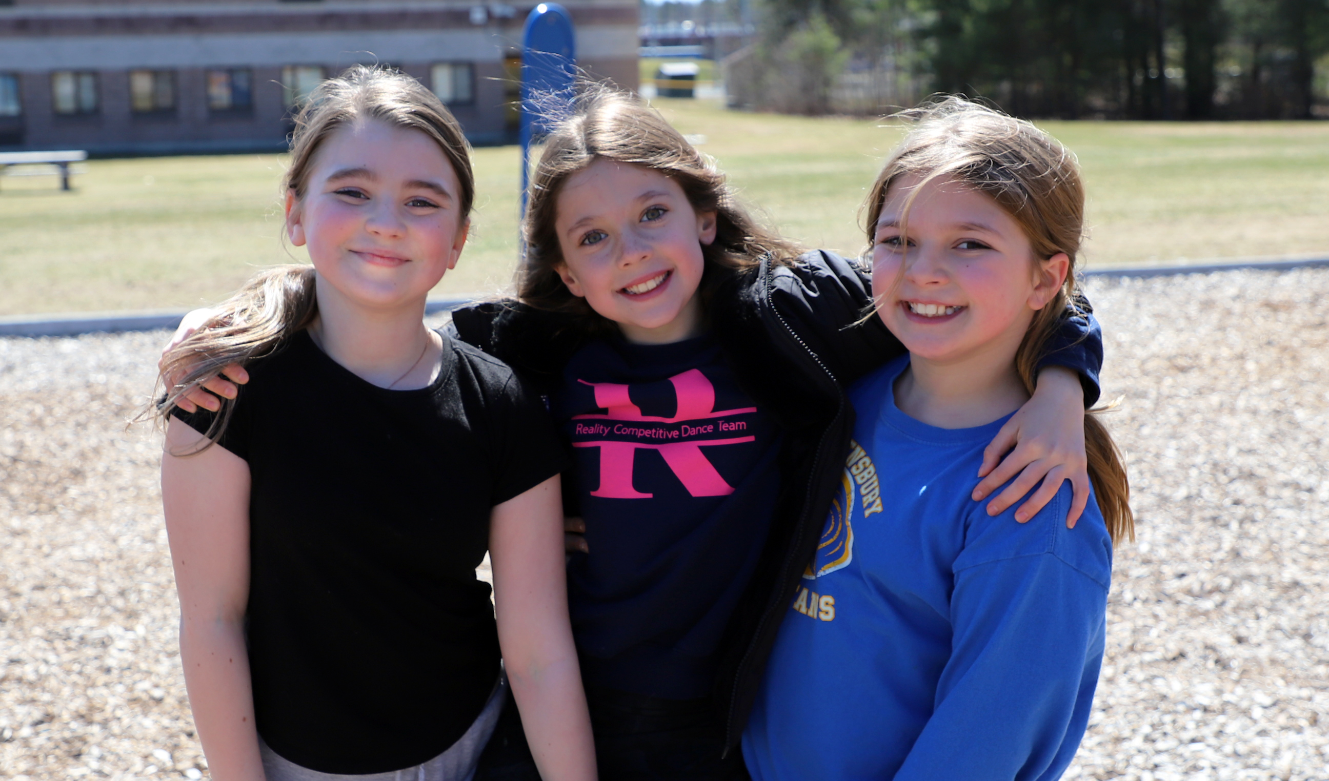 Three students play on the playground.