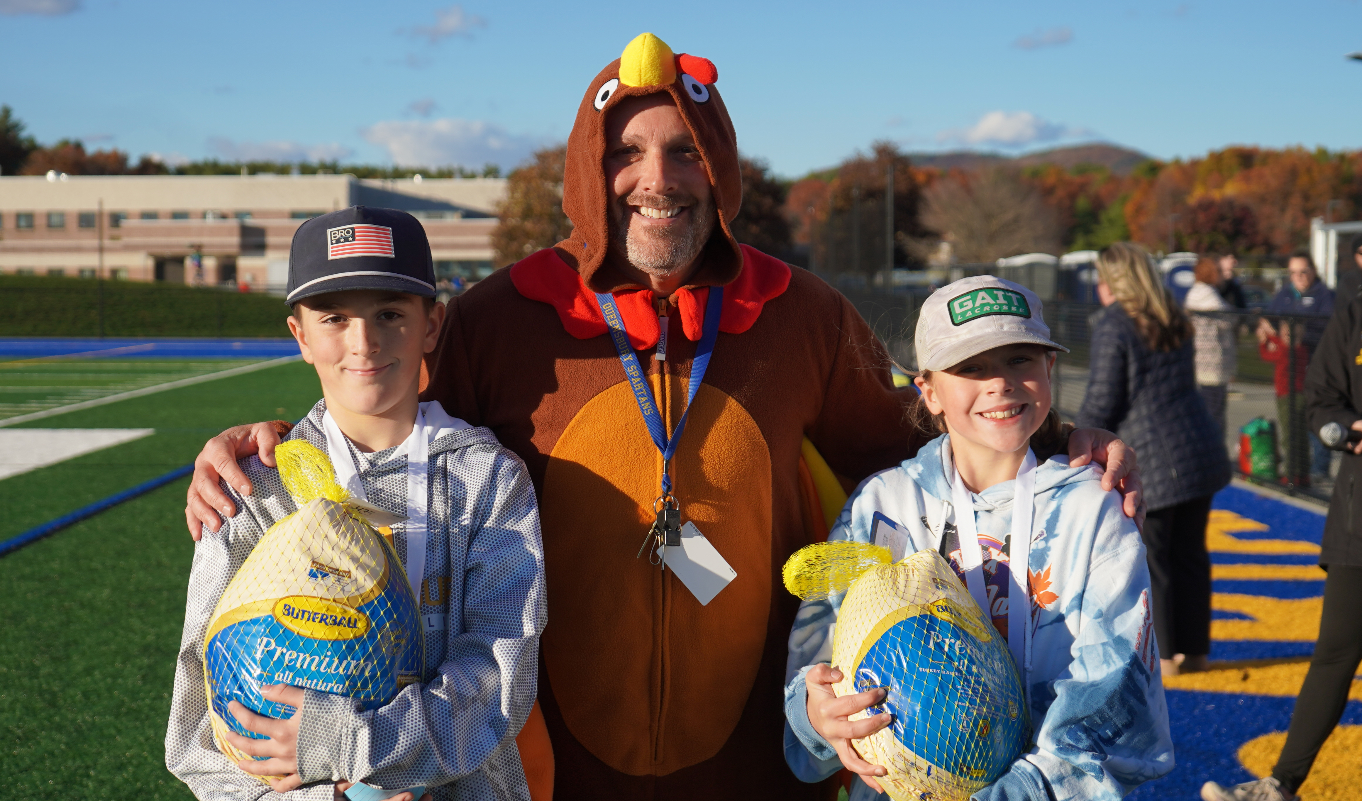 Two students and a PE teacher dressed like a turkey.