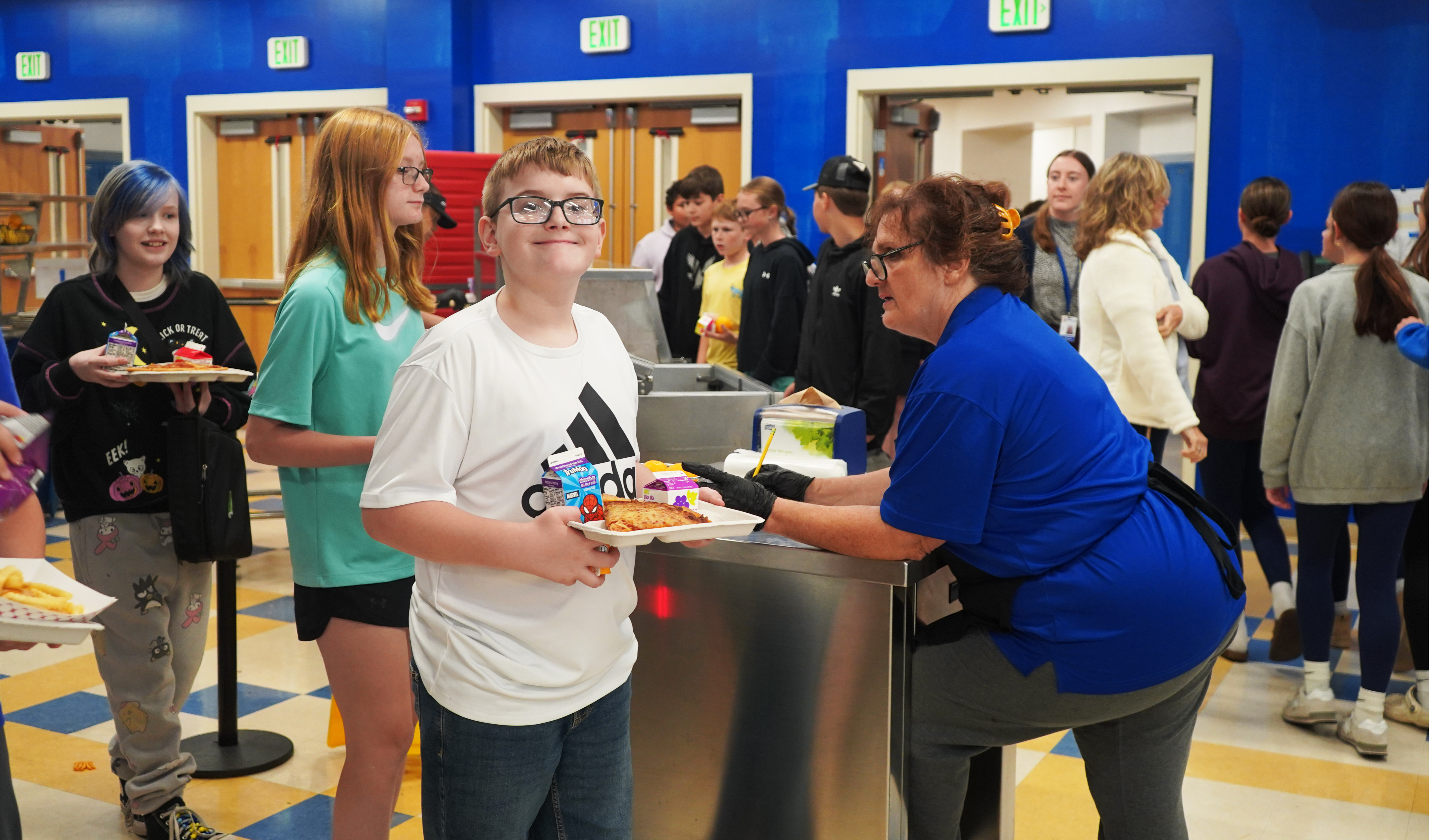 Student carries lunch in school cafeteria.