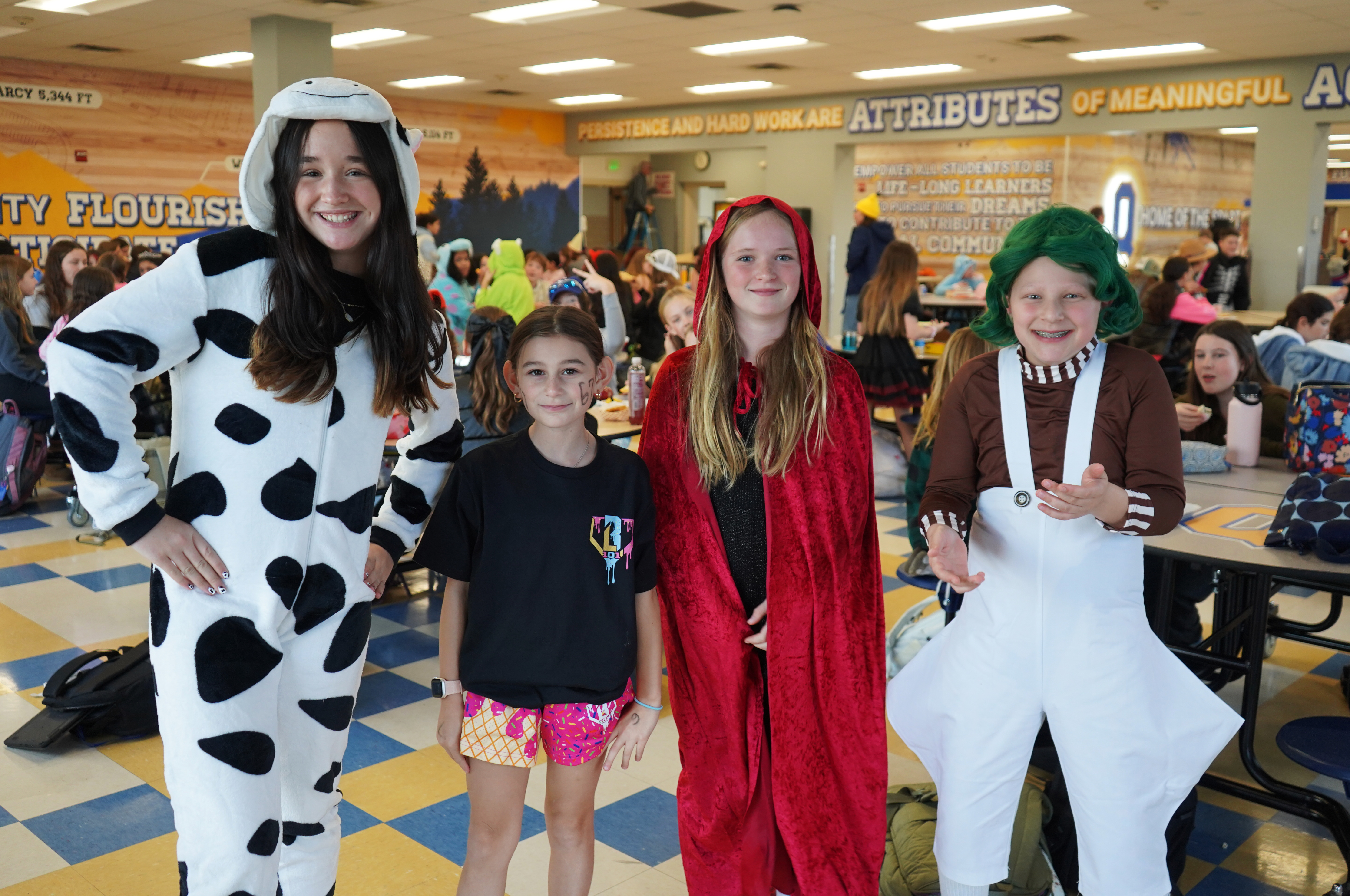 Students stand in cafeteria in Halloween costumes.