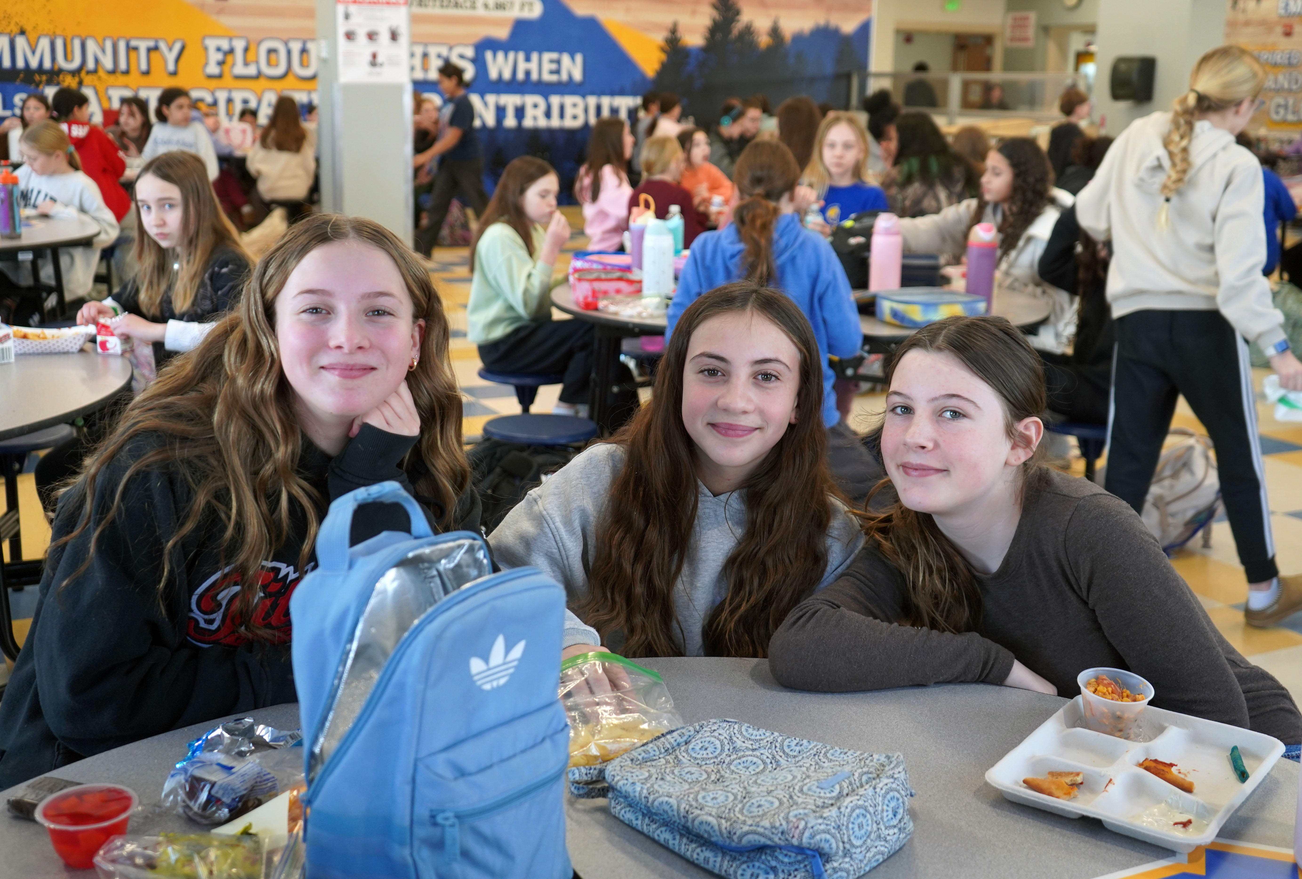 Three students eat lunch at QMS cafeteria.