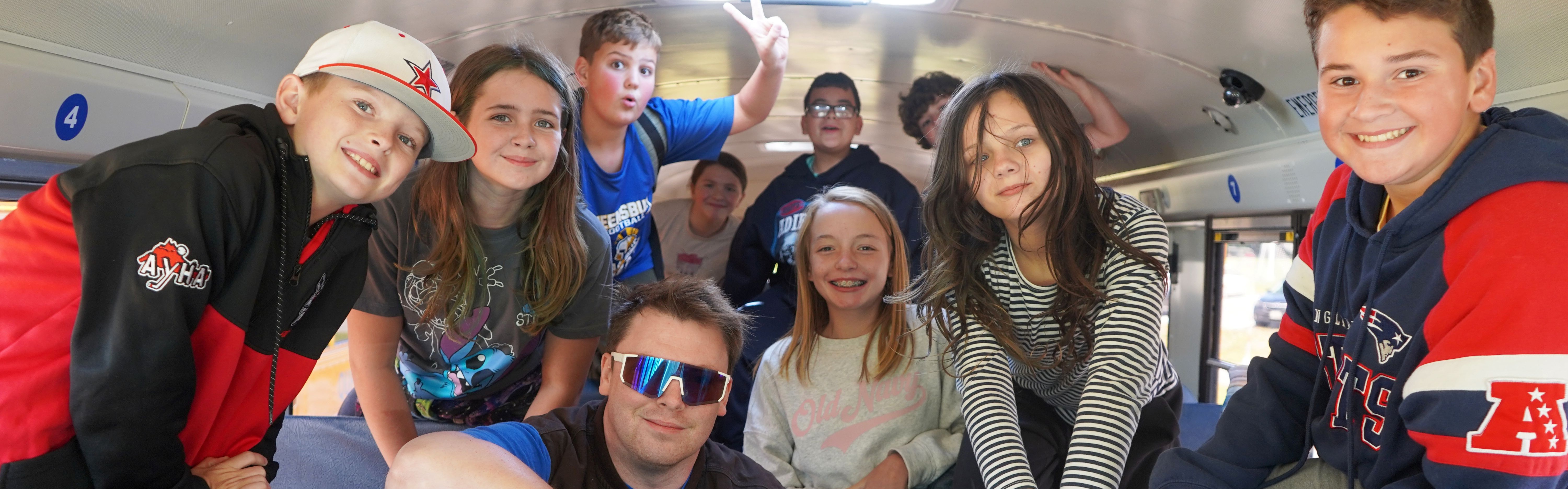 Students and bus driver on a school bus.