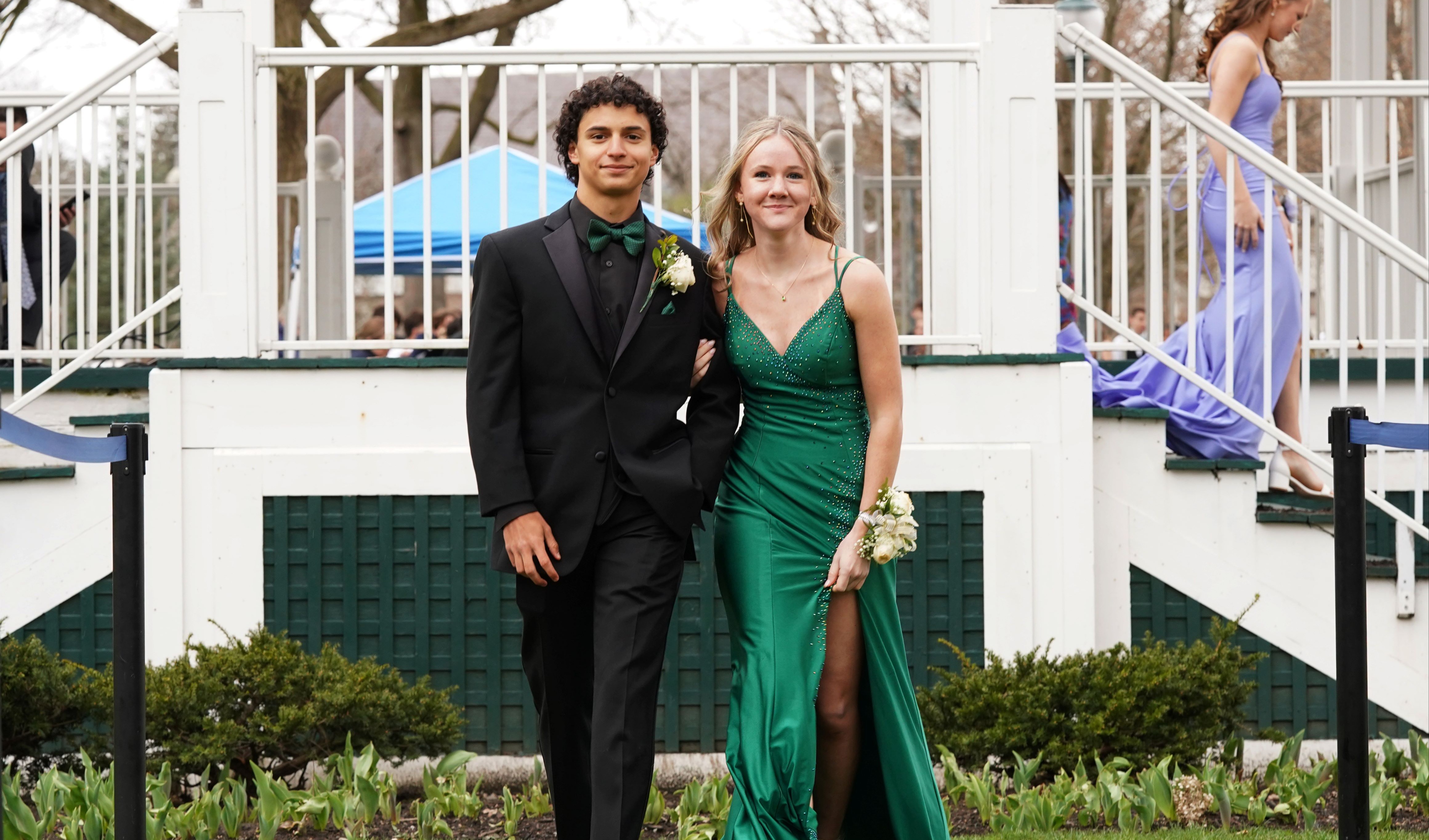Two teens walk together at prom.