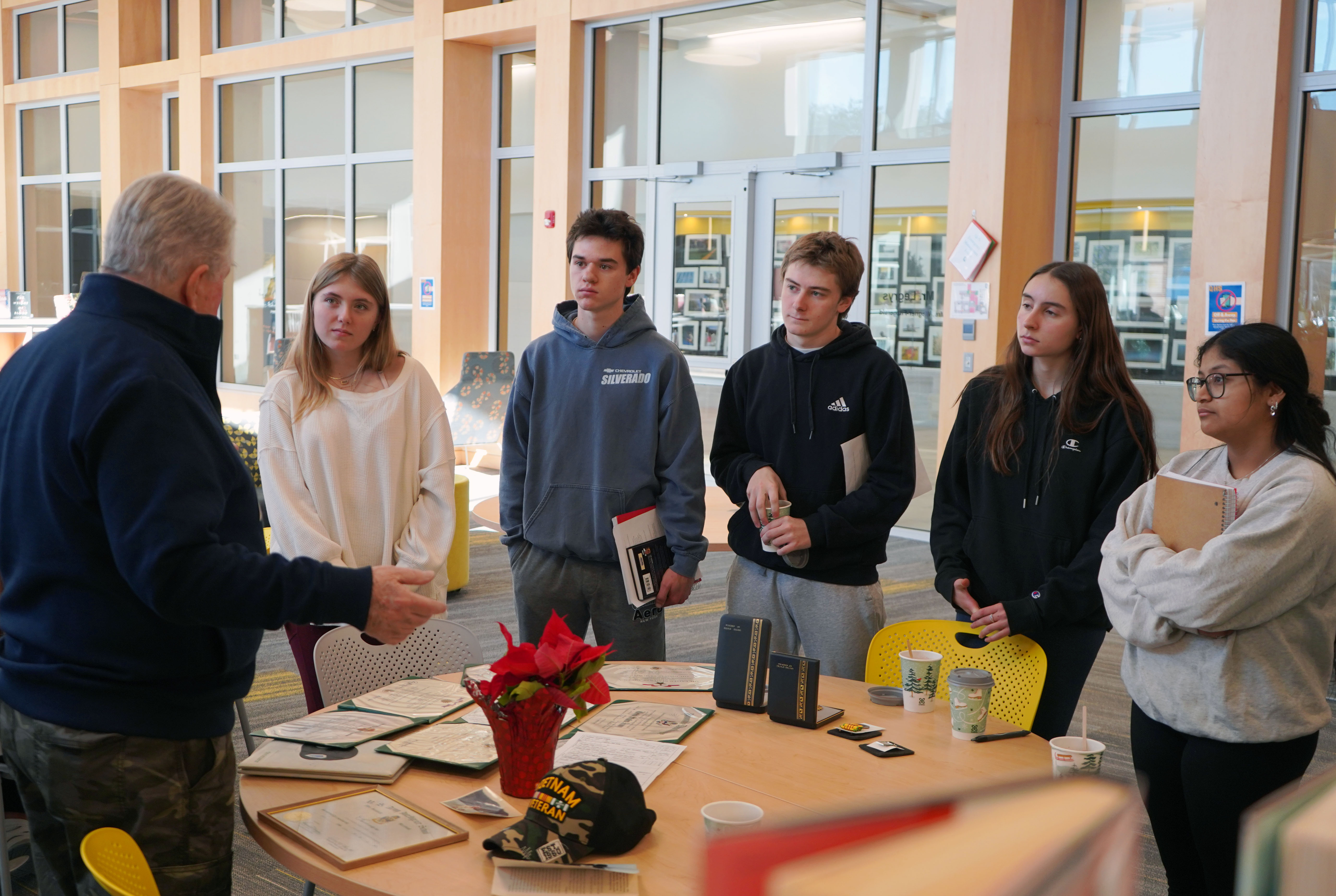 High school students listen to veteran talk about war. 