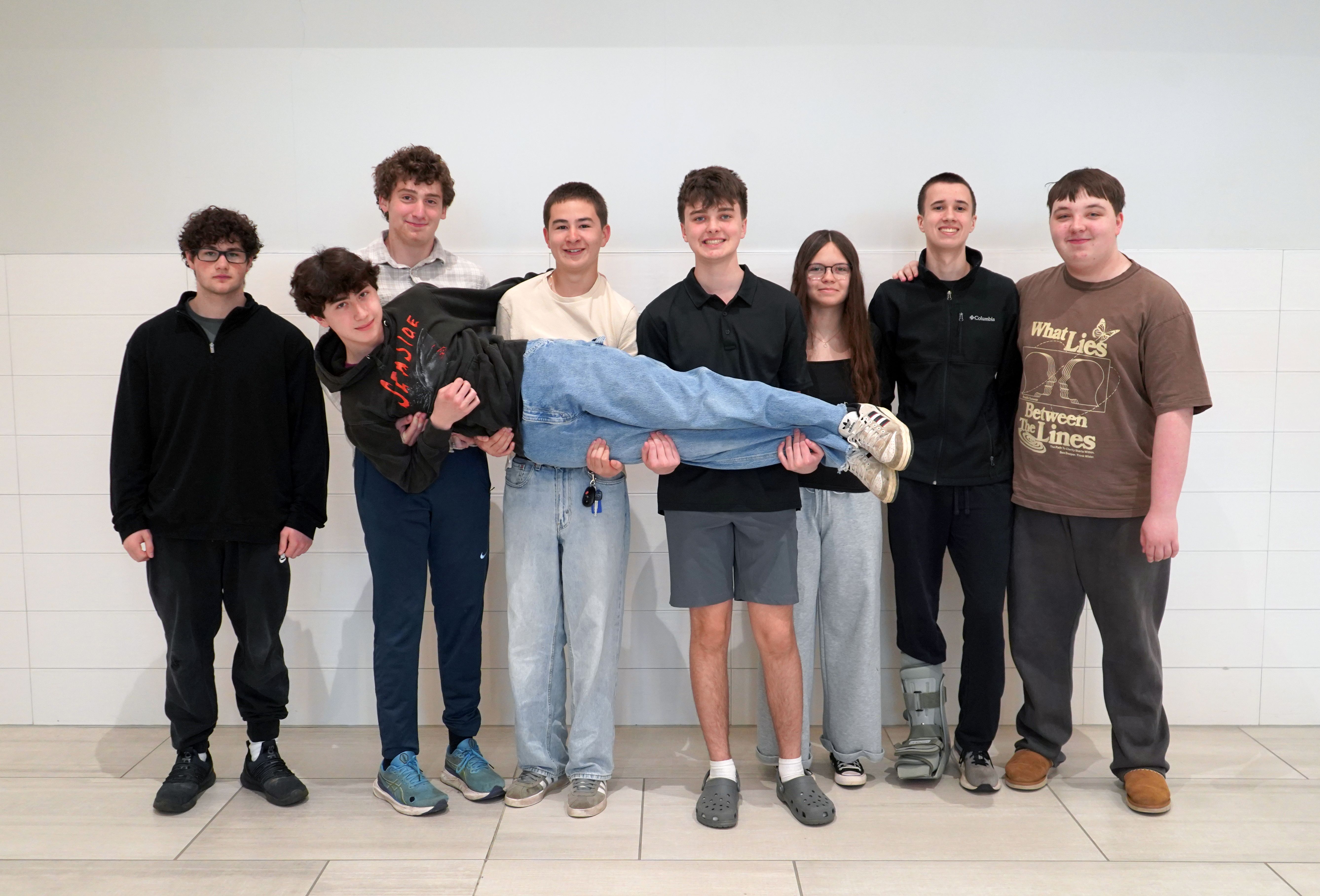 Students pose for photo in QHS lobby.