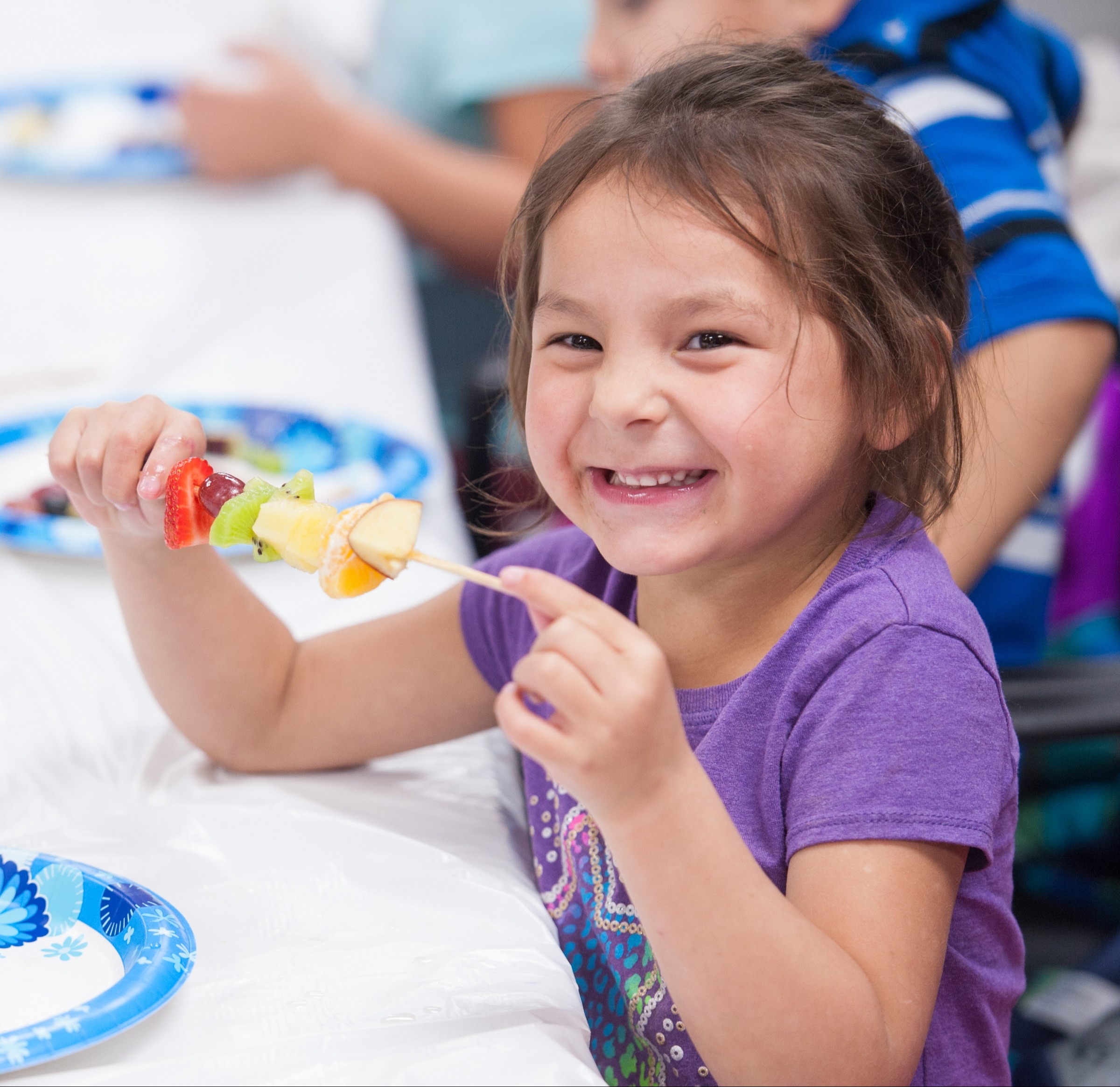 child eating fruit kabob