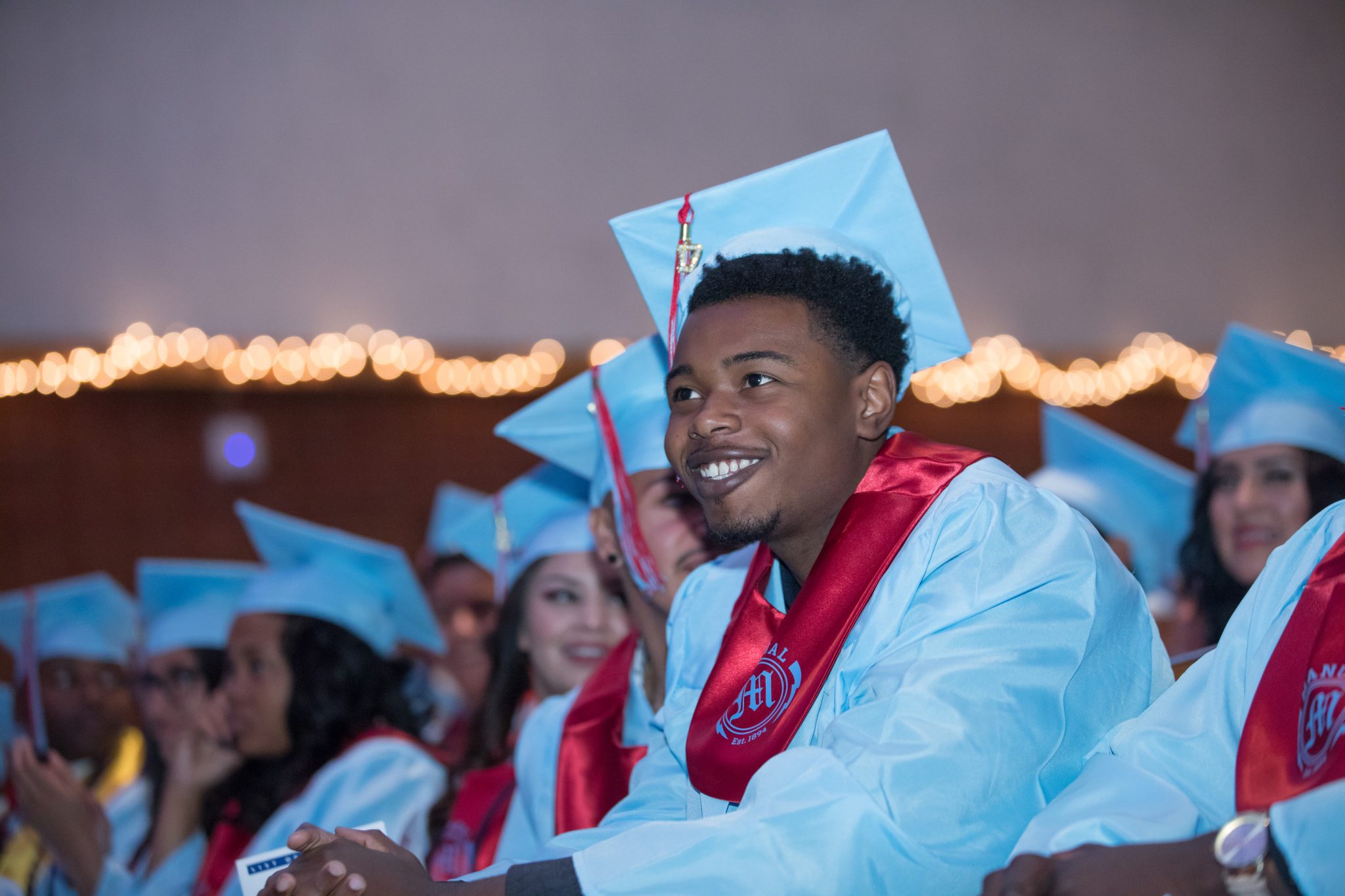 Group of kids at High School graduation wearing blue graduation gowns