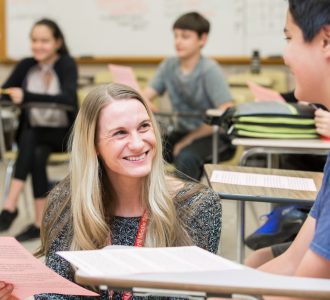 Teacher smiling to student at classroom