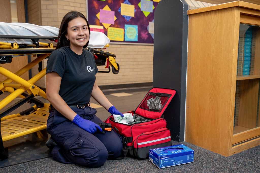 Young paramedic woman smiling at school hall
