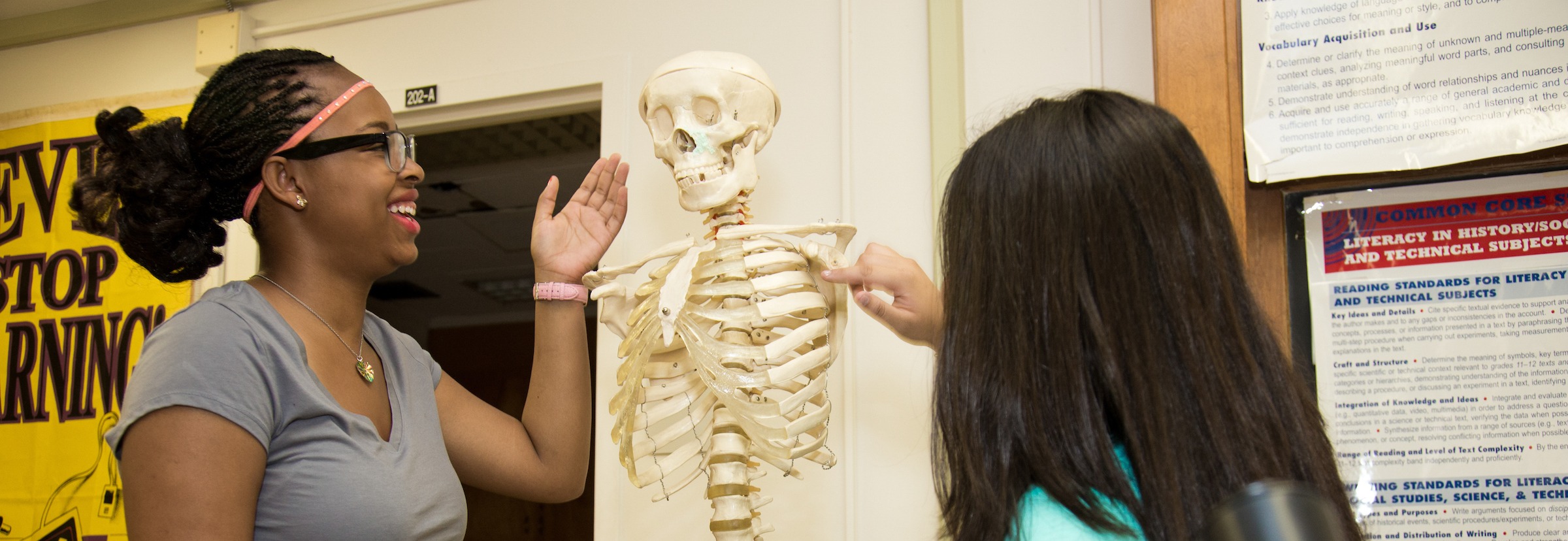 Two girls looking at skeleton at science class