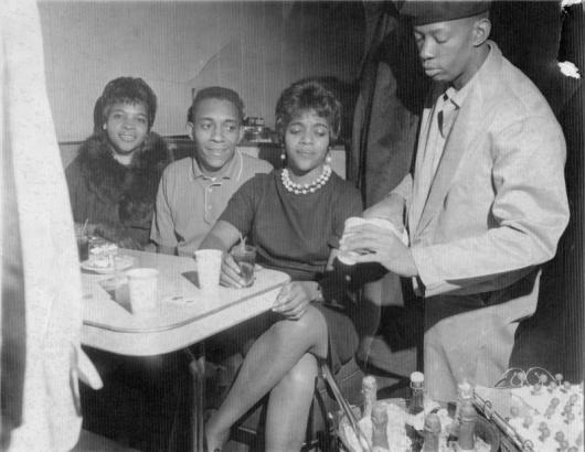 Customers being served by waiter at Rice's Tap Room and Oven. Image from Denver Library.