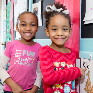 Two girls smiling at classroom