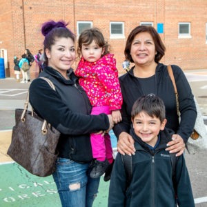  Two kids posing for photo with their mom and their grandma