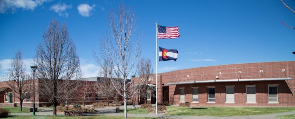 Colorado and USA flags waving, School building on the back