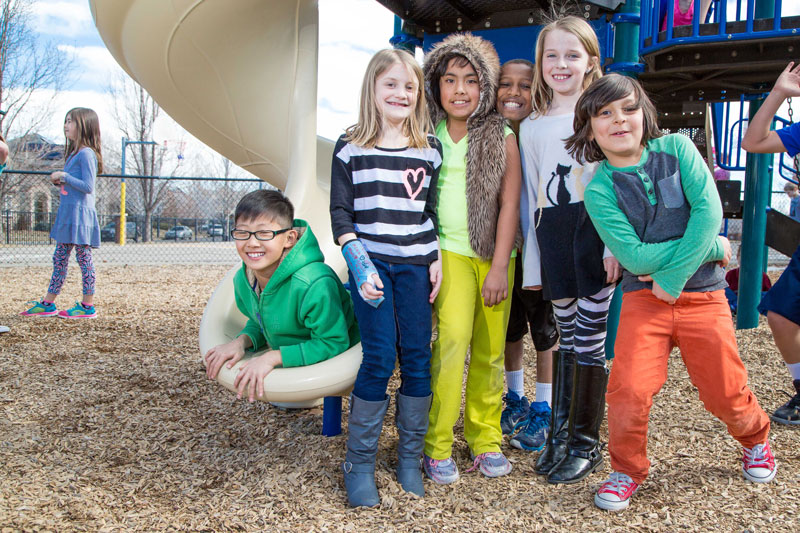 Group of kids smiling posing for photo at the playground