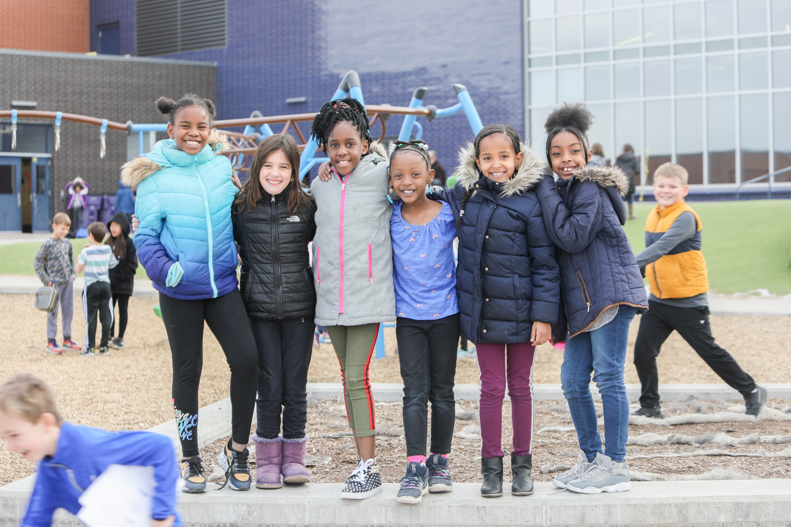 Group of young girls posing for photo at school playground