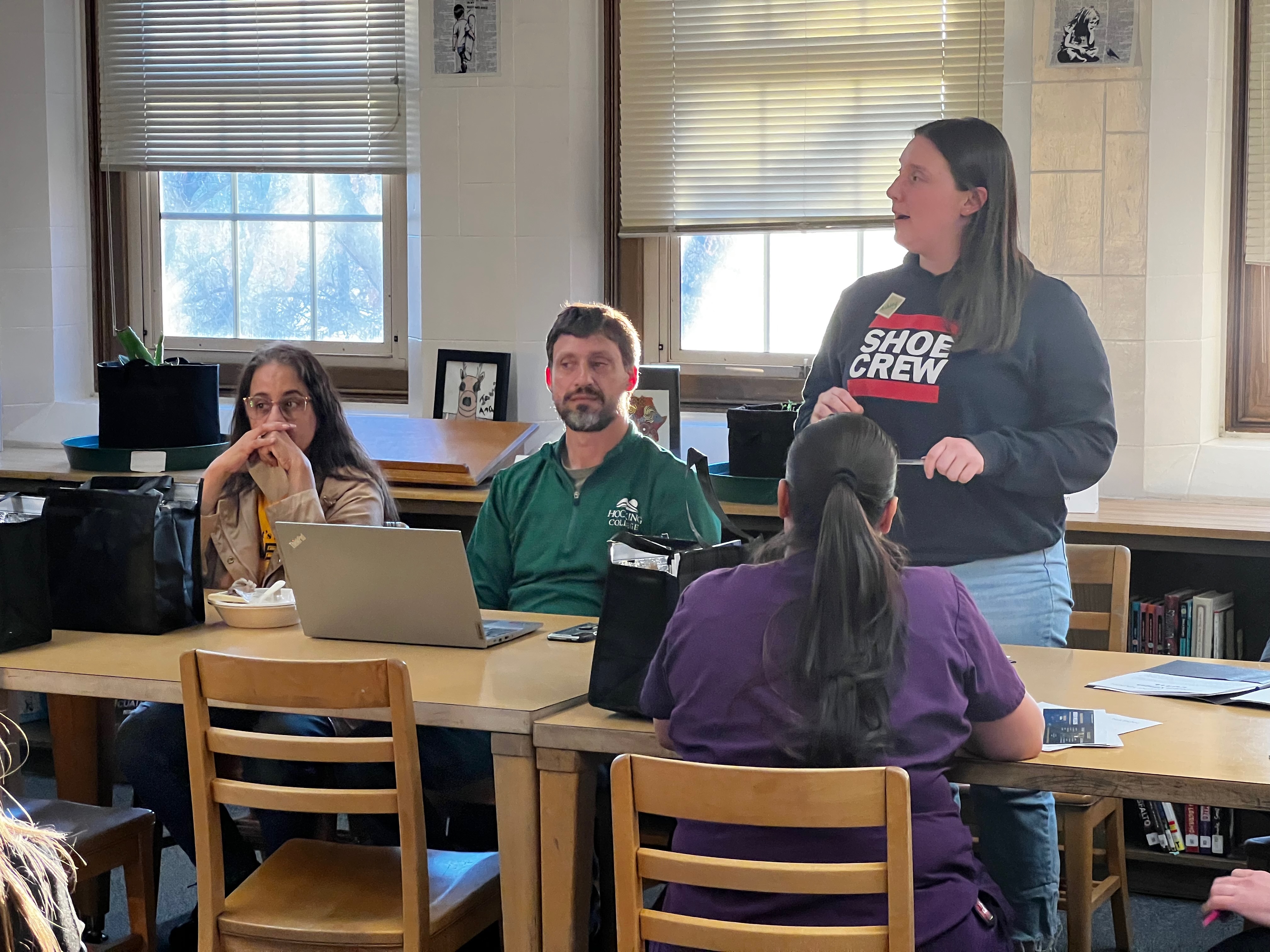 Four people sitting at a table, engaged in a discussion. They appear to be having a collaborative and thoughtful conversation.