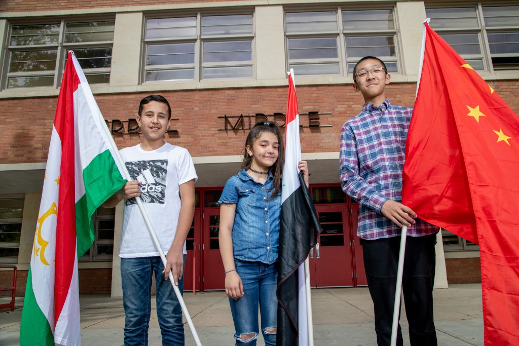Three kids holding flags of different countries